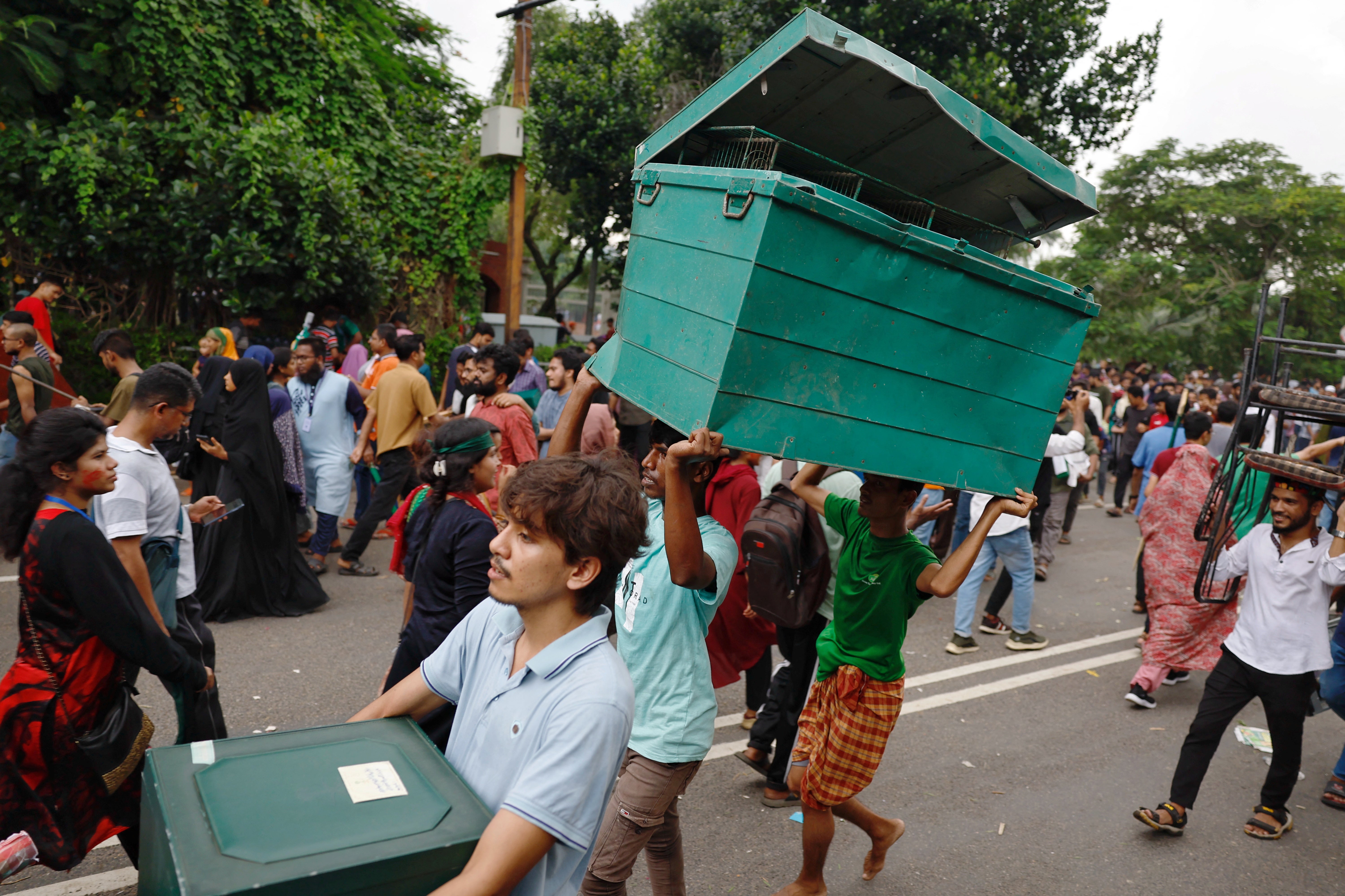 Protesters loot a big metal box from the prime minister's residence in Dhaka, Bangladesh, on 5 August 2024