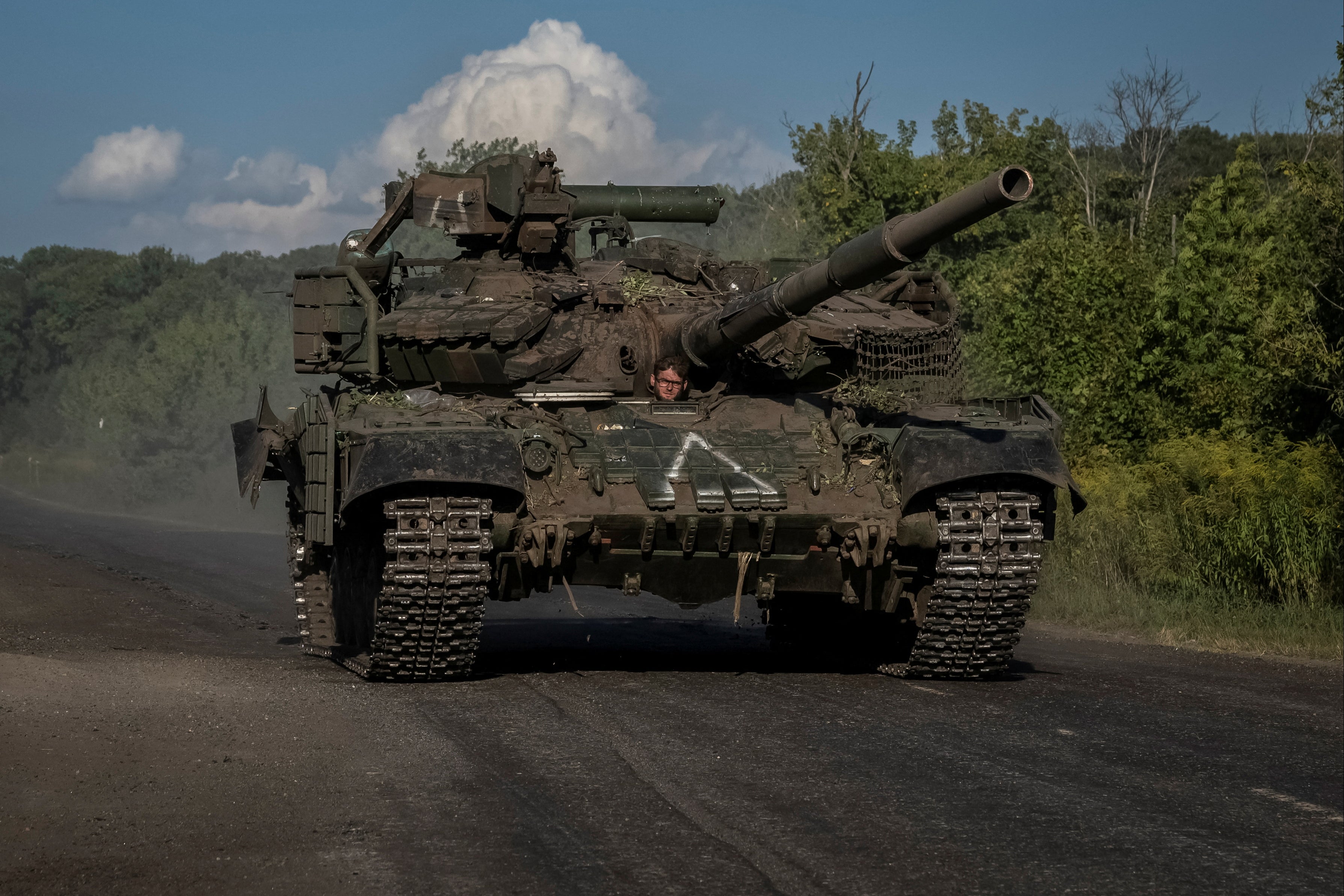 Ukrainian servicemen ride a tank near the Russian border in Sumy region