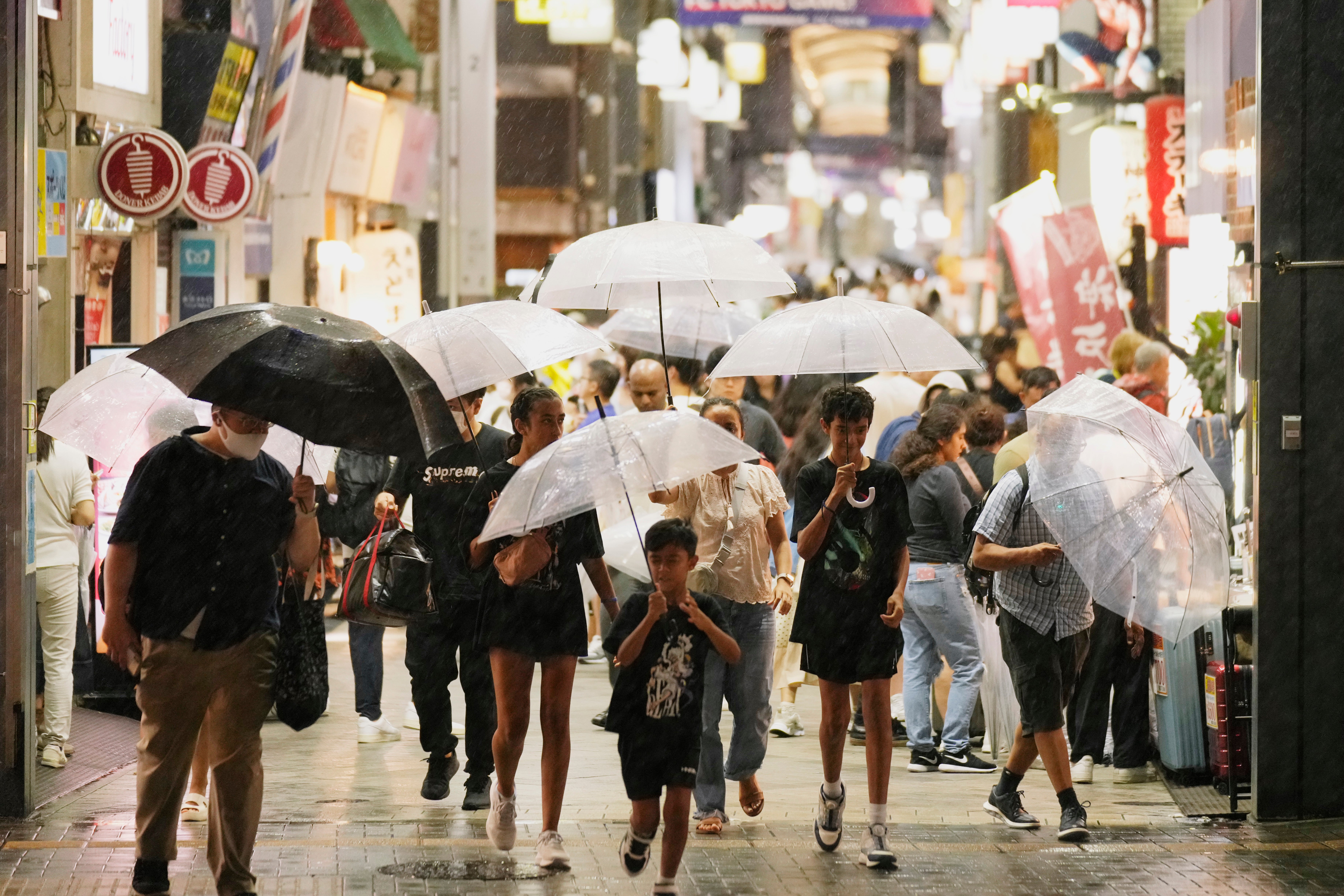 People walk through a shopping street in Tokyo, Friday, 16 August 2024