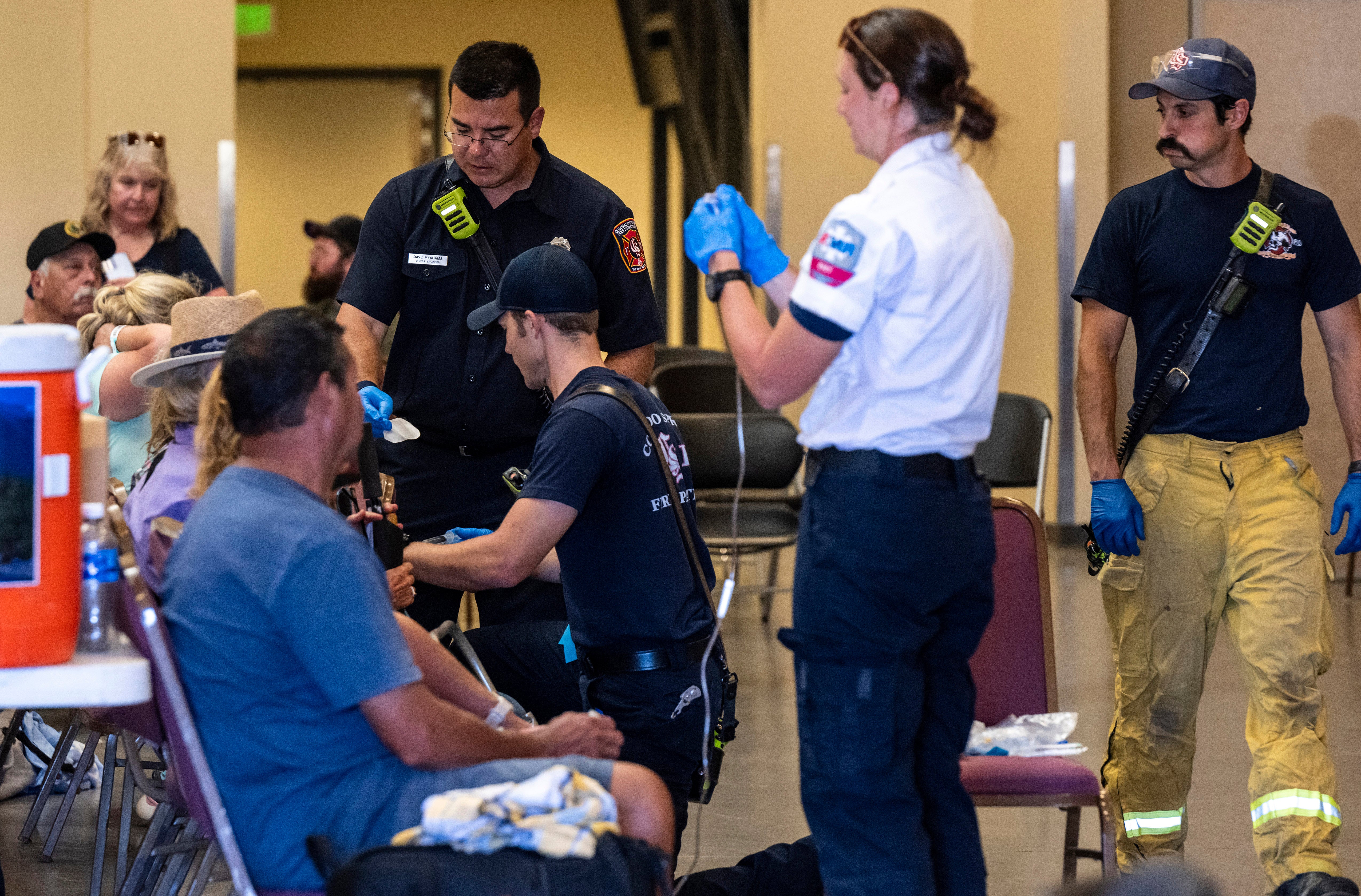 Members of the Colorado Springs Fire Department and AMR paramedics treat people for heat-related illness at the Pikes Peak Regional Airshow