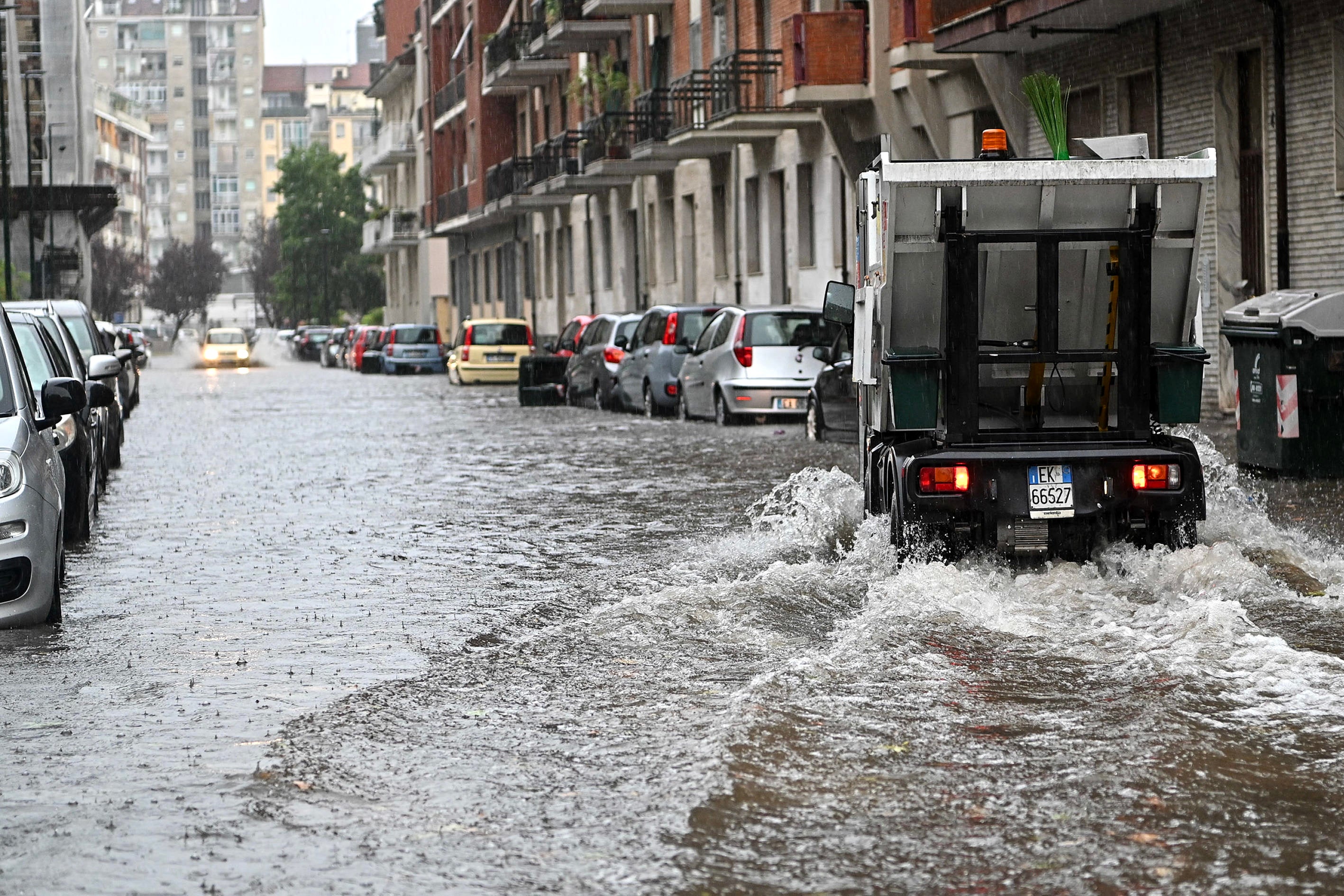 A car drives in a waterlogged street following a heavy storm in Turin, northern Italy, 14 August 2024