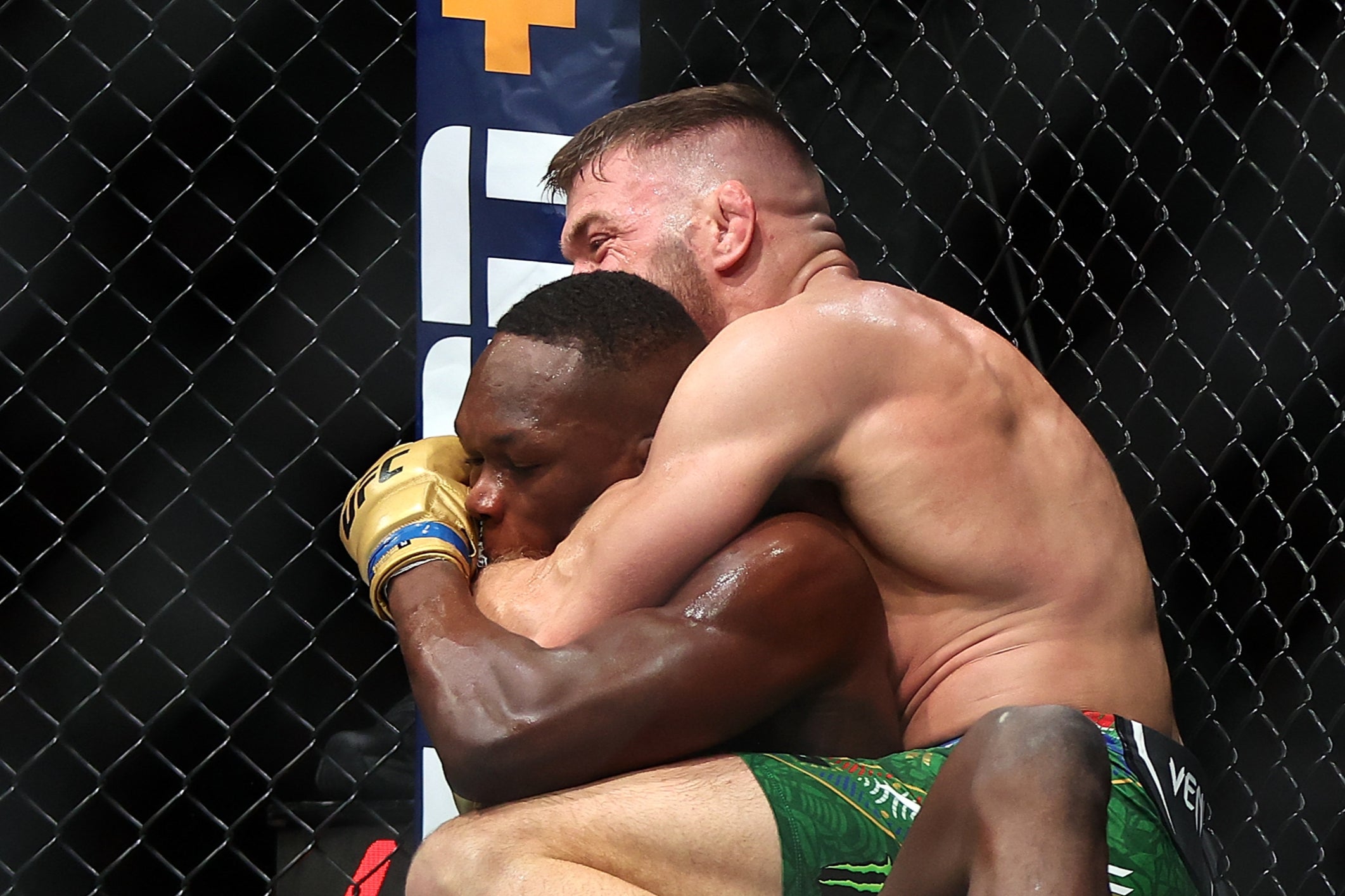 Israel Adesanya (left) tries to prevent Dricus Du Plessis from locking in a choke