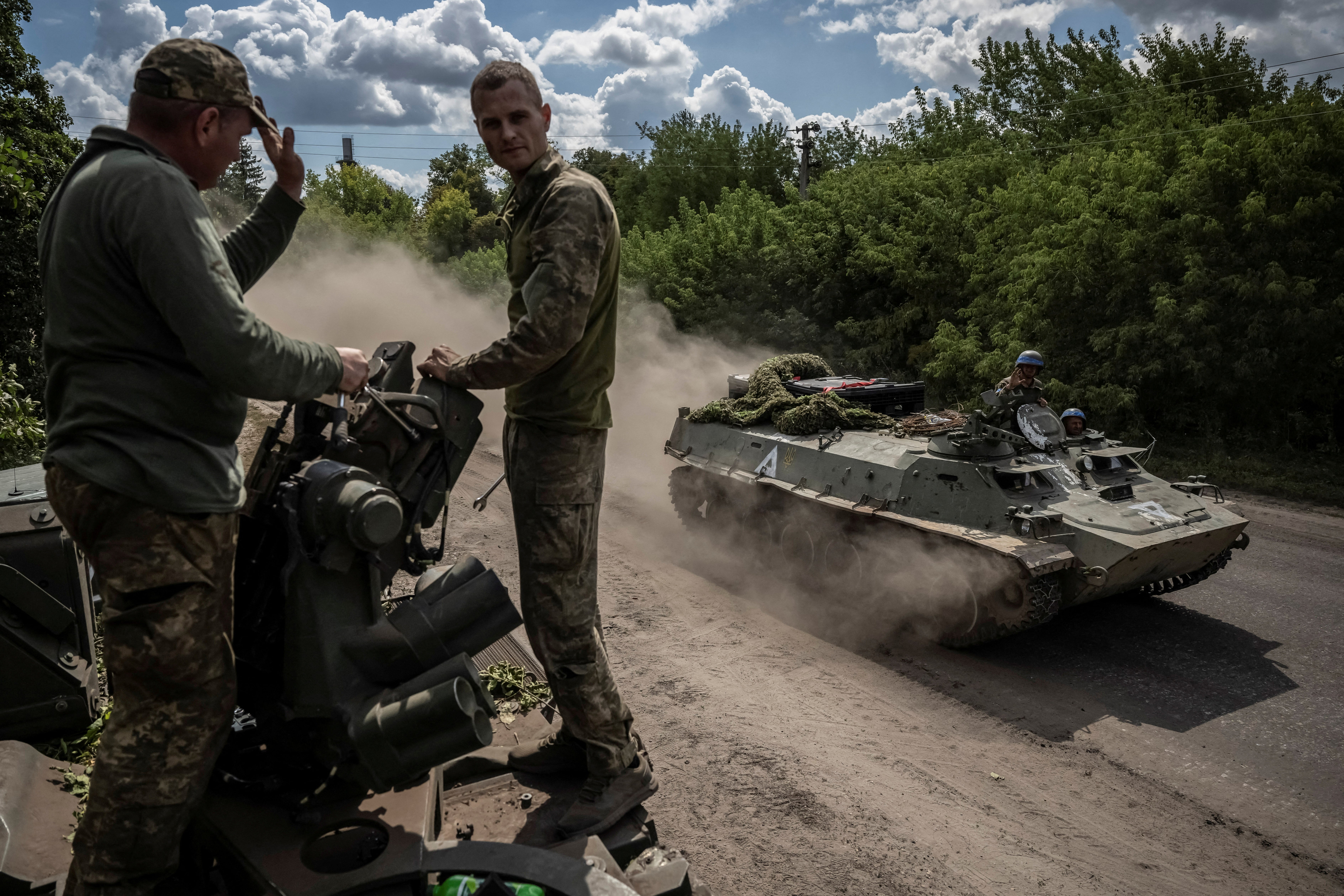 Ukrainian service members ride an armoured personnel carrier in Sumy, near the Russian border