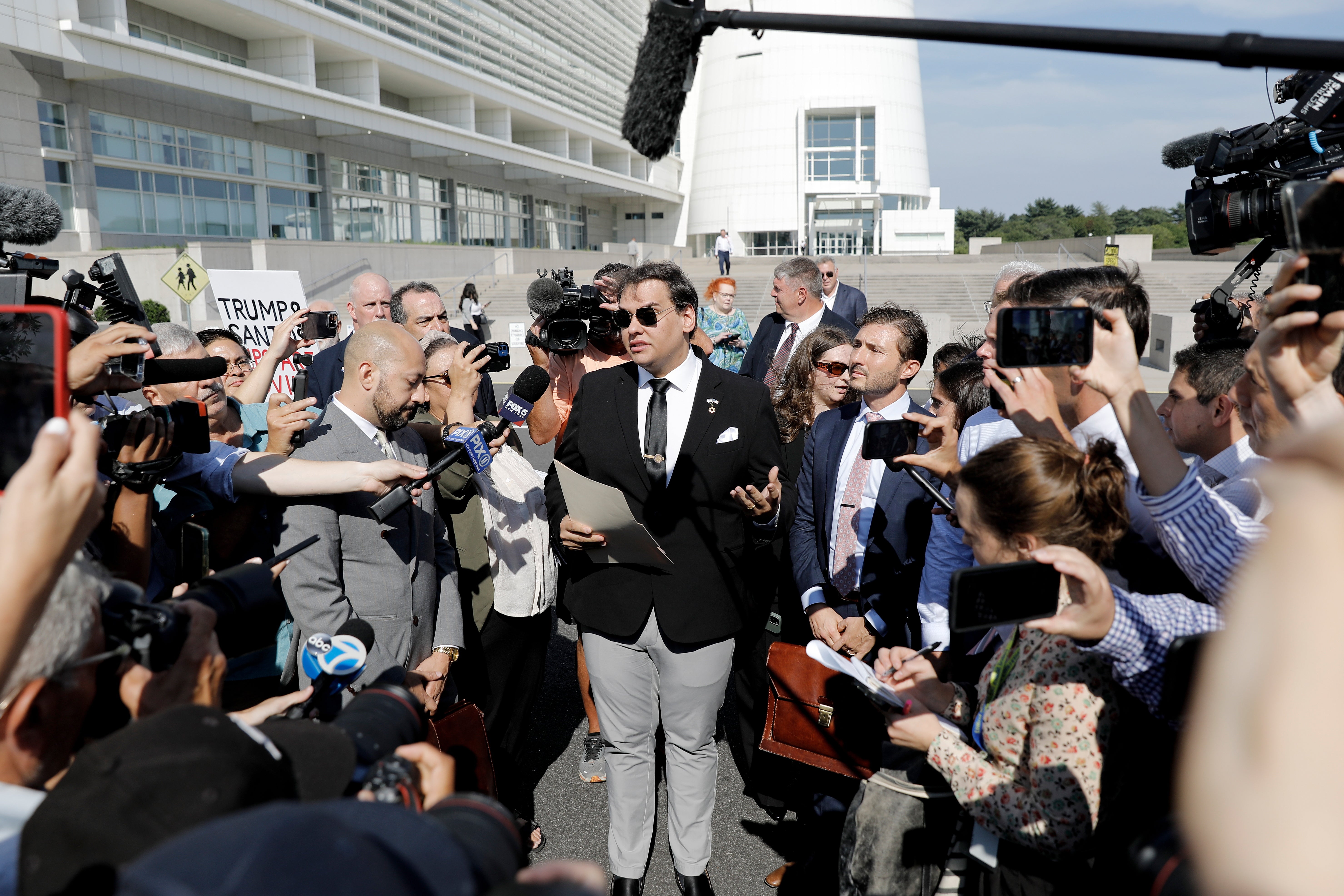 George Santos speaking to reporters after leaving federal court in Central Islip, New York on Monday. The former congressman faces prison time after pleading guilty to aggravated identity theft and wire fraud