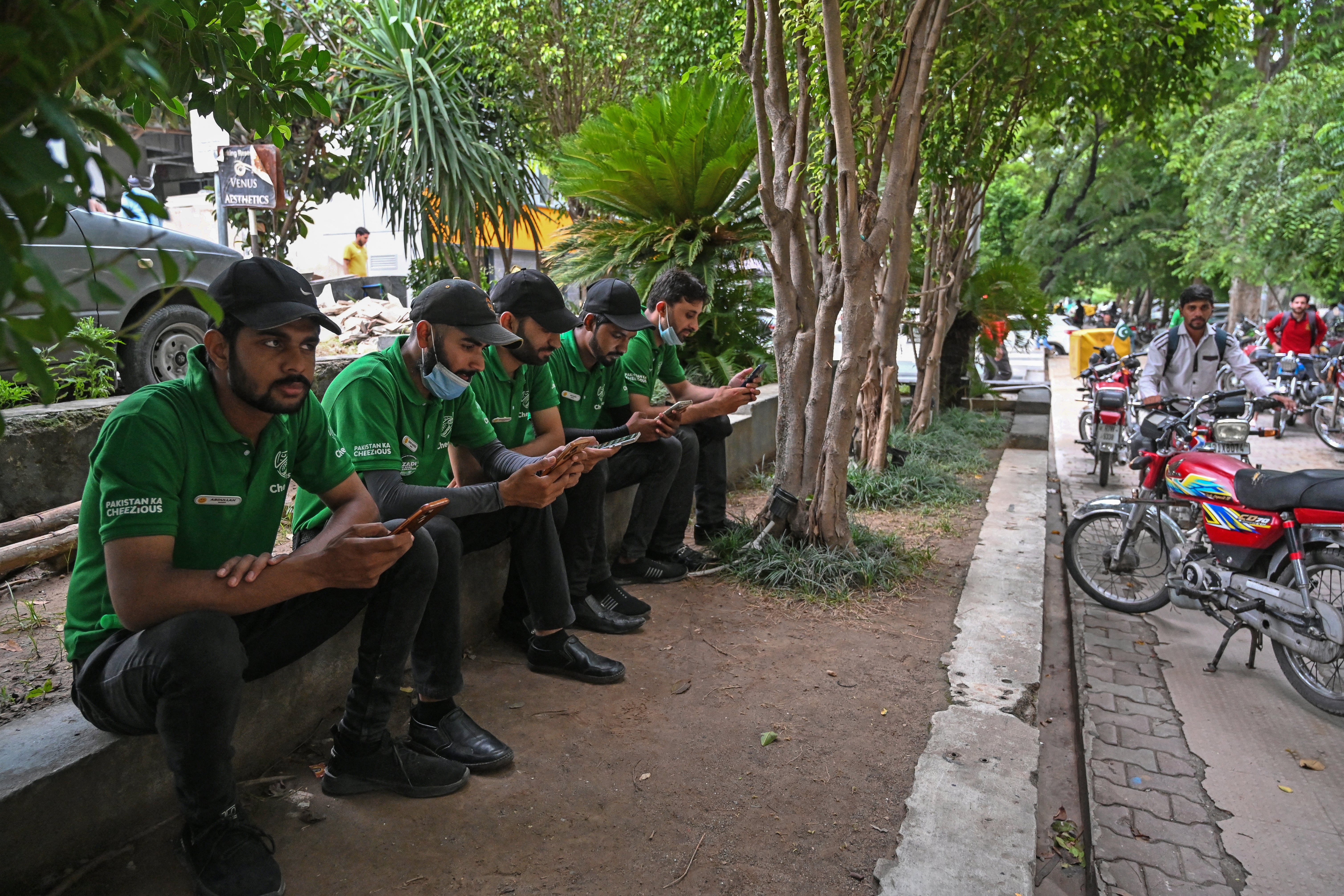 Food delivery men in Islamabad waiting for their mobile phone data to work