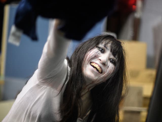 <p>File. Actress Haruna Suzuki cleaning up fake blood from a car following a demonstration of a haunted house in Tokyo</p>