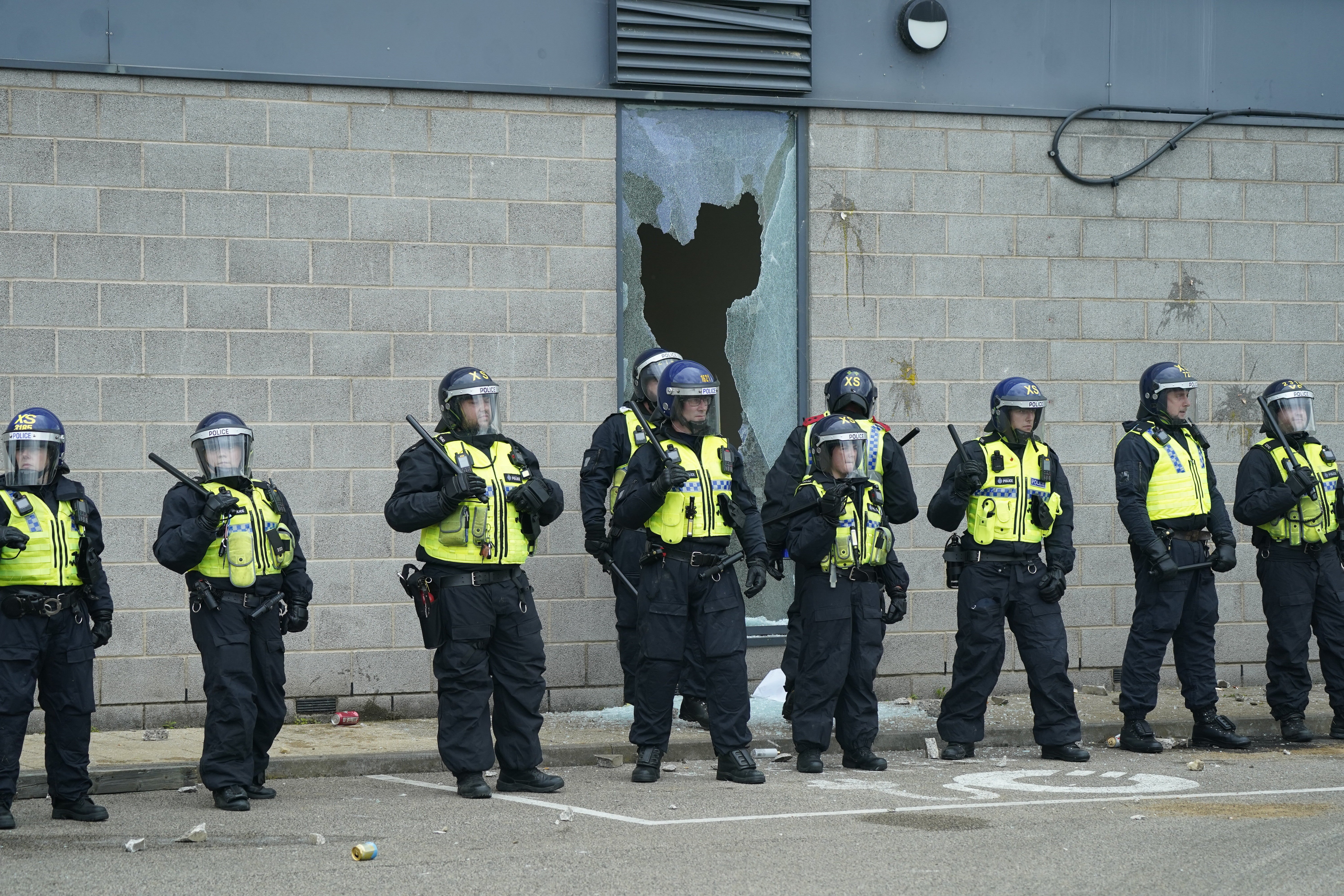 Police officers in front of a smashed window as trouble flared during an anti-immigration protest outside the Holiday Inn Express in Rotherham, South Yorkshire on August 4 (Danny Lawson/PA)