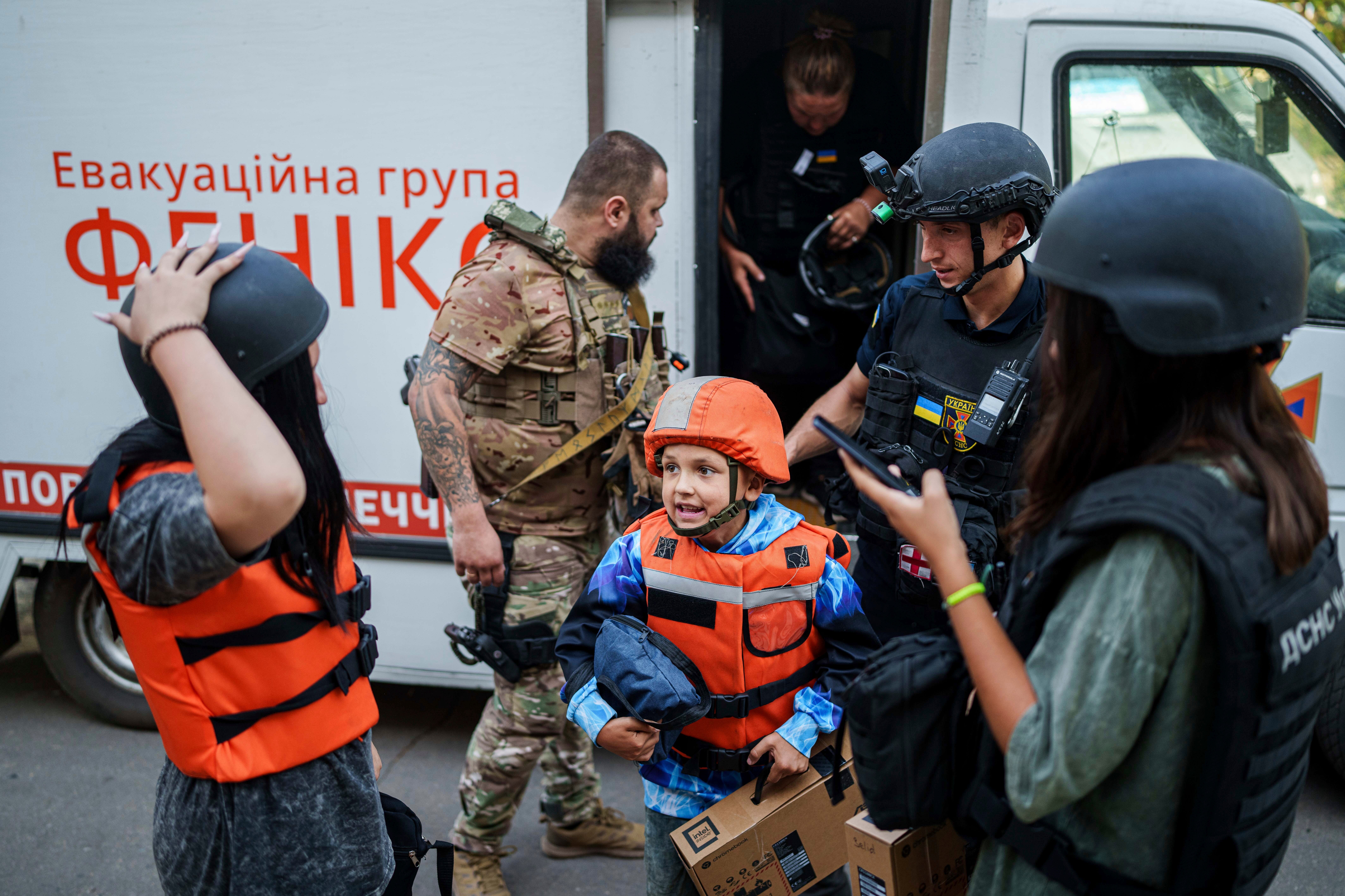 A young boy, his sister and his mother step off an armoured van on Tuesday used for evacuations from the Pokrovsk area