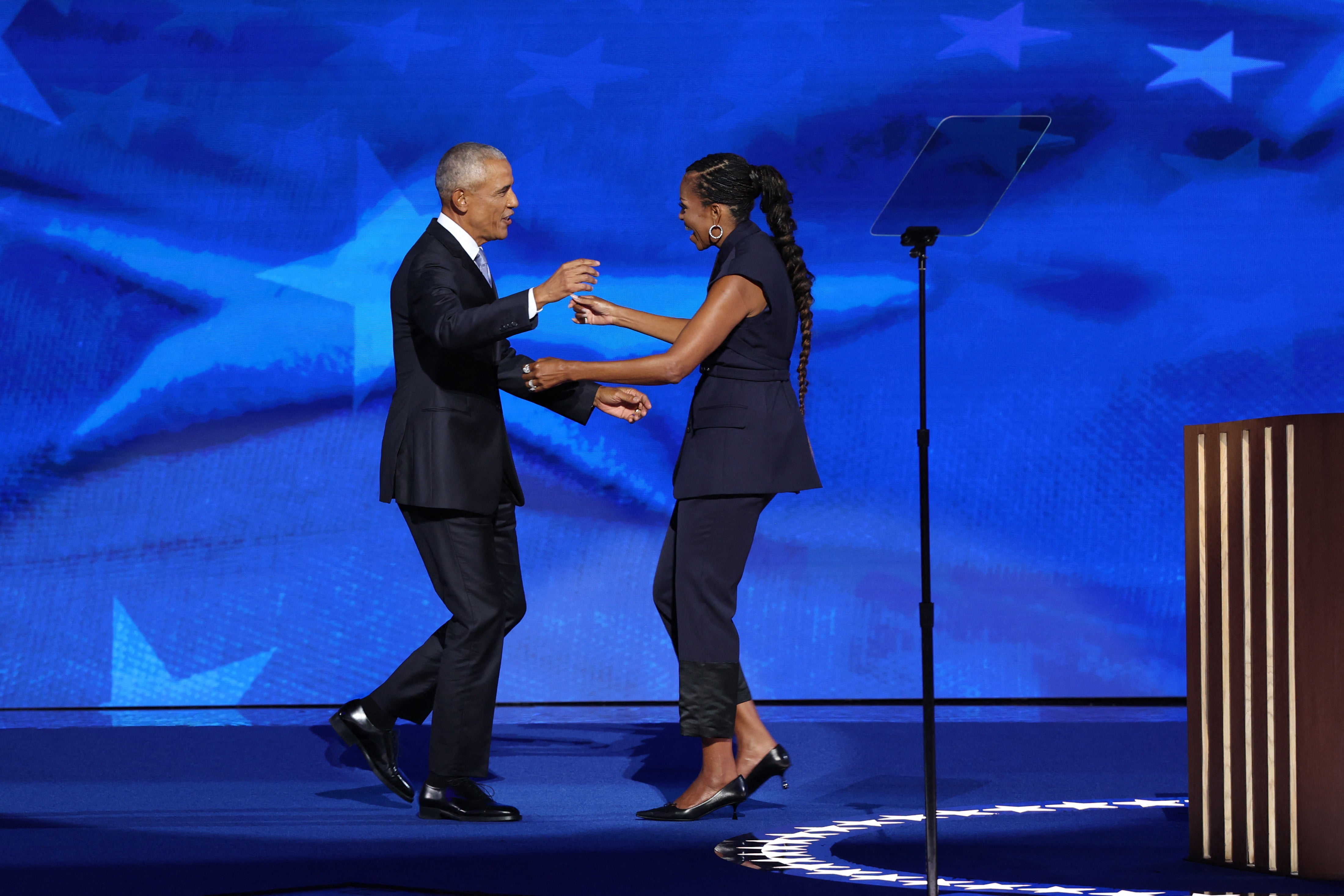 Michelle Obama greets her husband Barack Obama on stage before his speech during Day two of the Democratic National Convention in Chicago