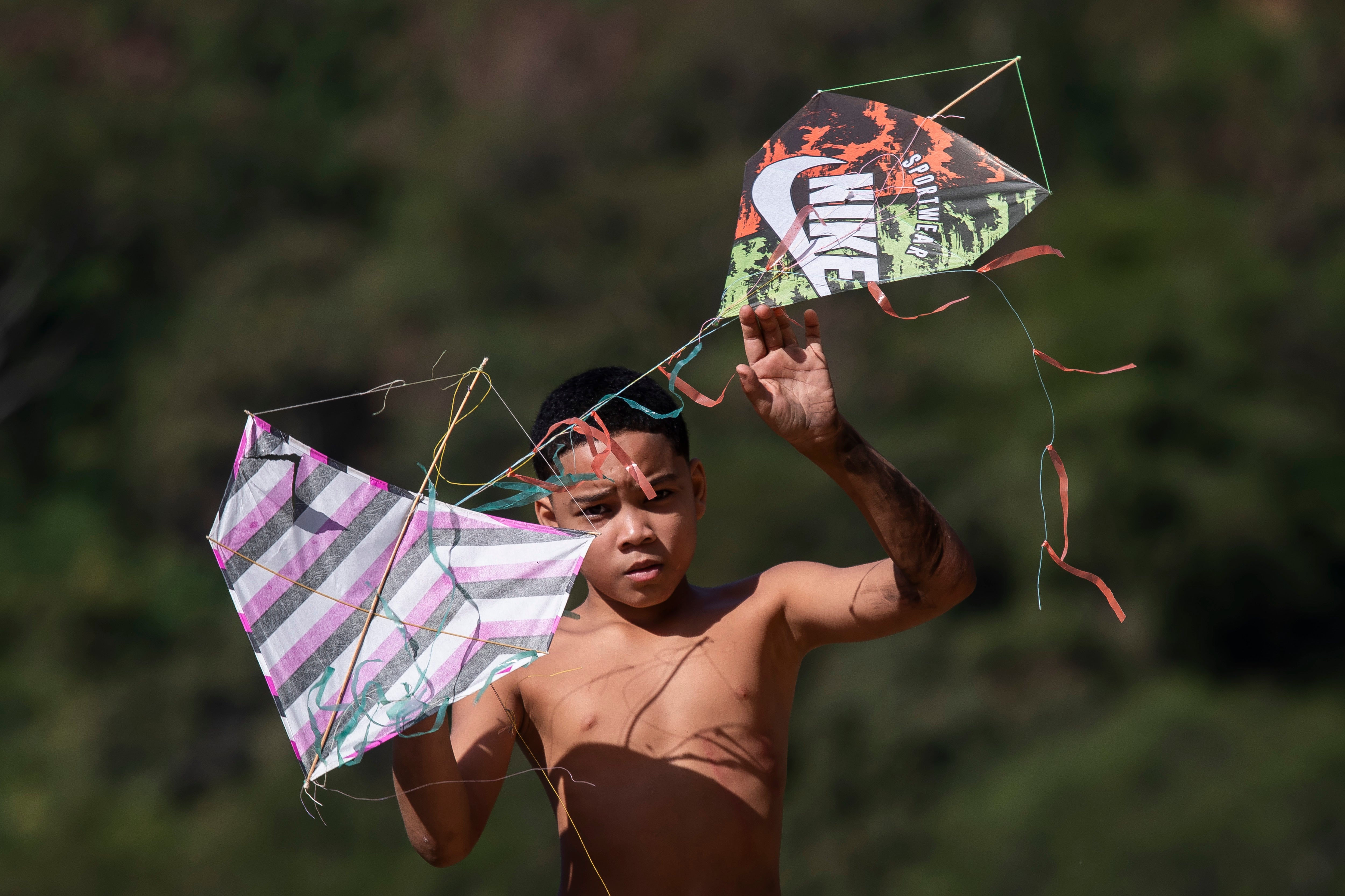 A youth holds kites during a festival in the Turano favela in Rio de Janeiro, Sunday,