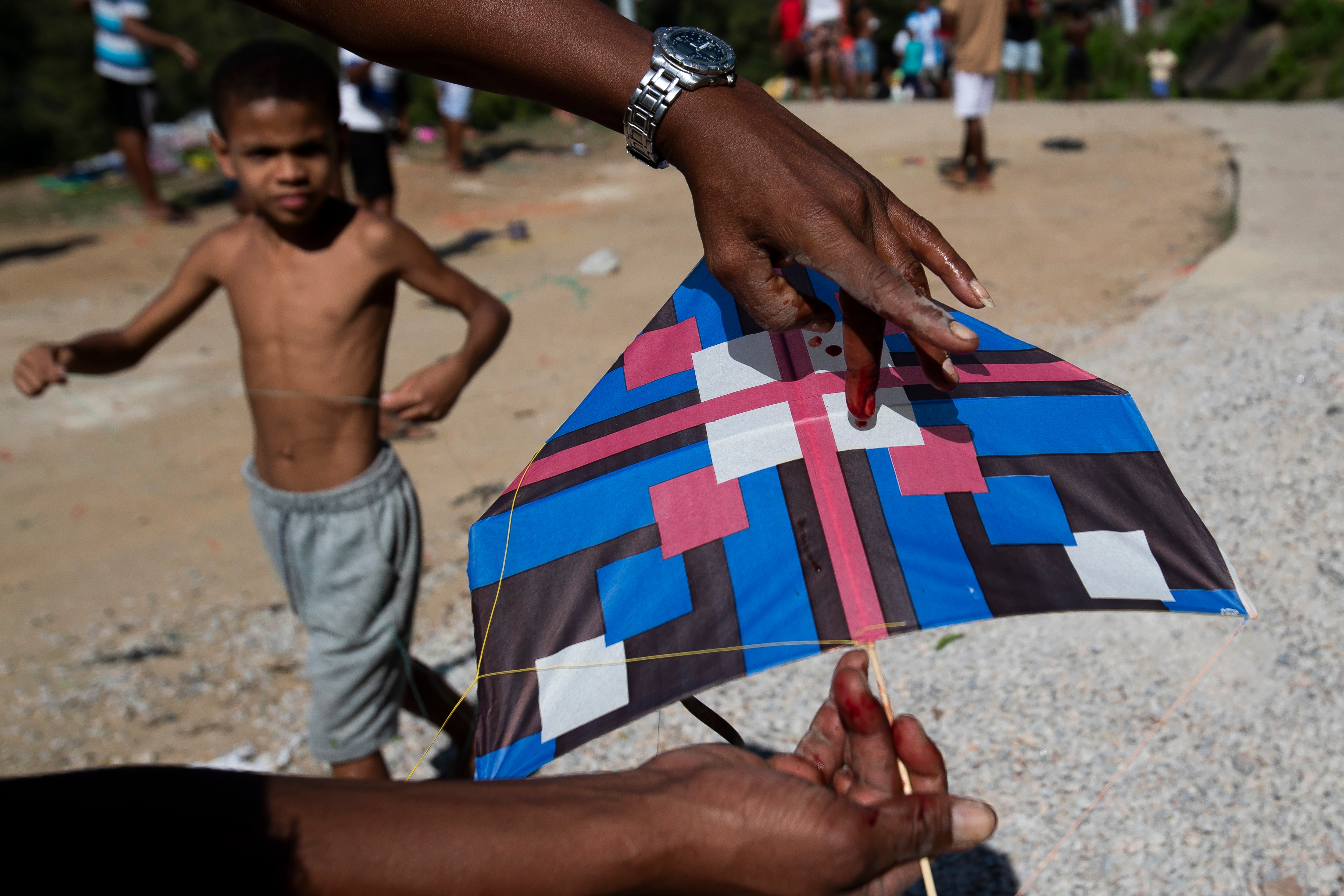 A kite-flier’s finger is bloodied by a line during a kite festival in the Turano favela in Rio de Janeiro