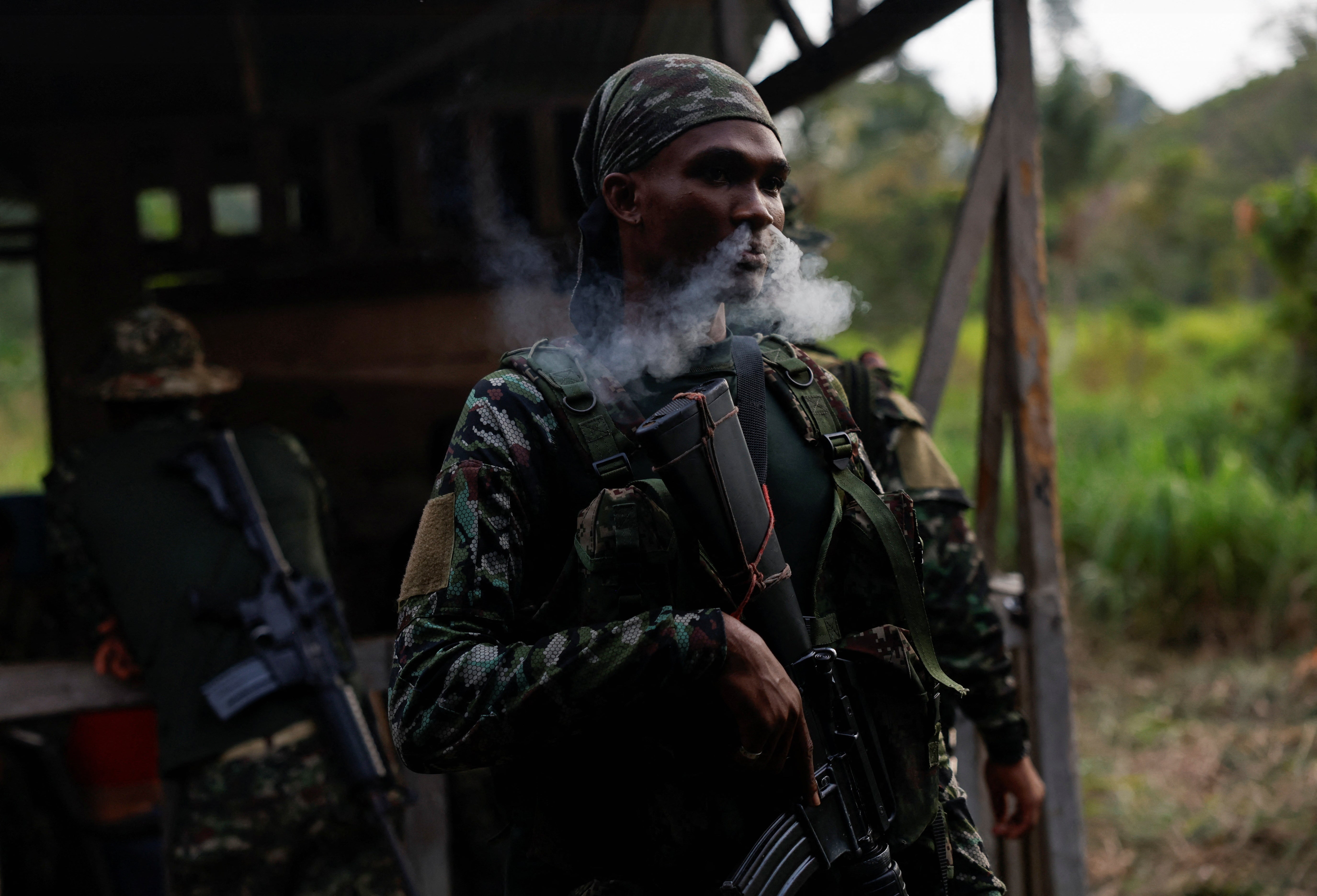 A guerrilla of Colombian rebel group Segunda Marquetalia smokes a cigarette before going on patrol