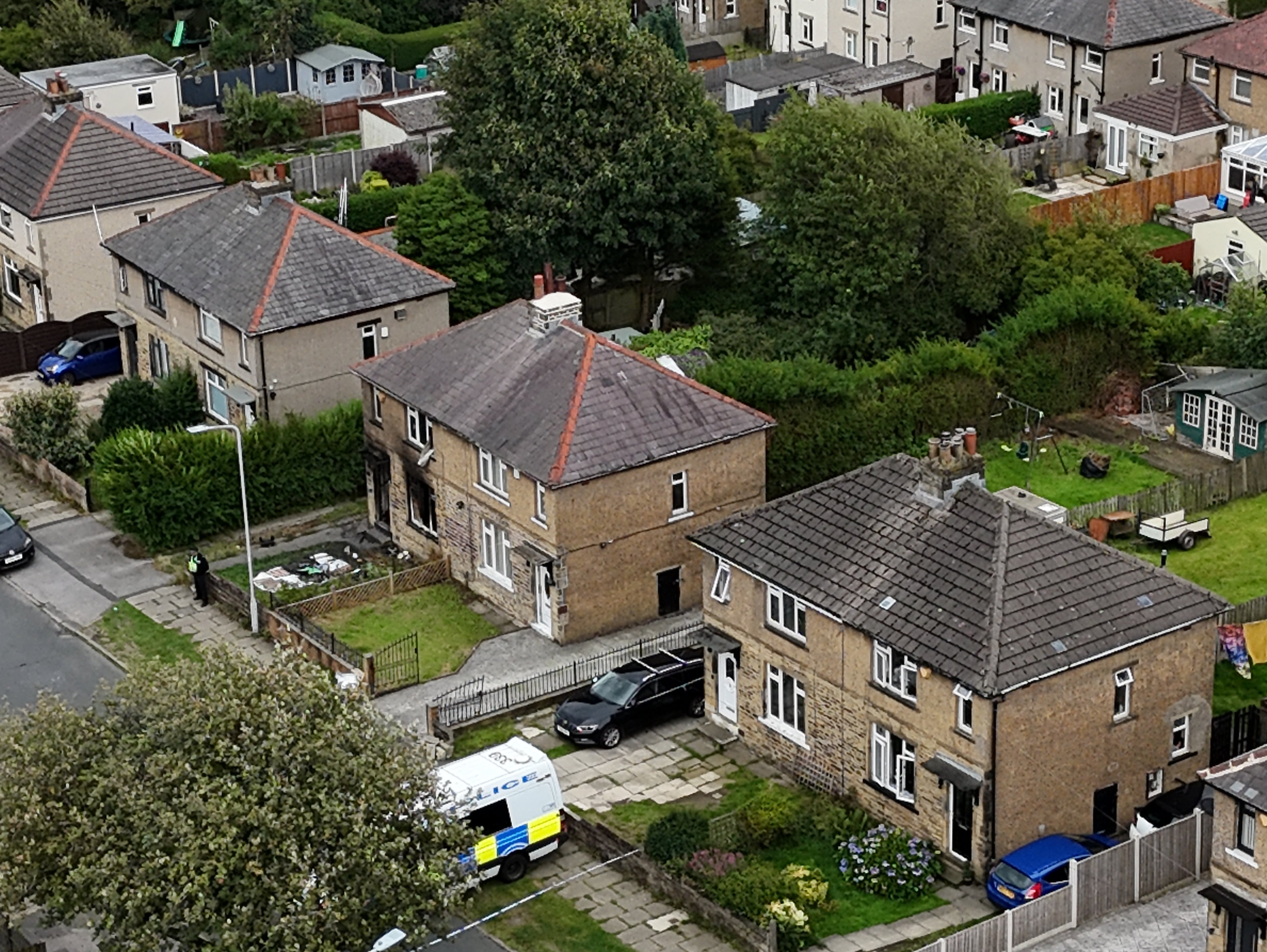 Emergency services in Westbury Road, Bradford, following a house fire where four people, including three children, died