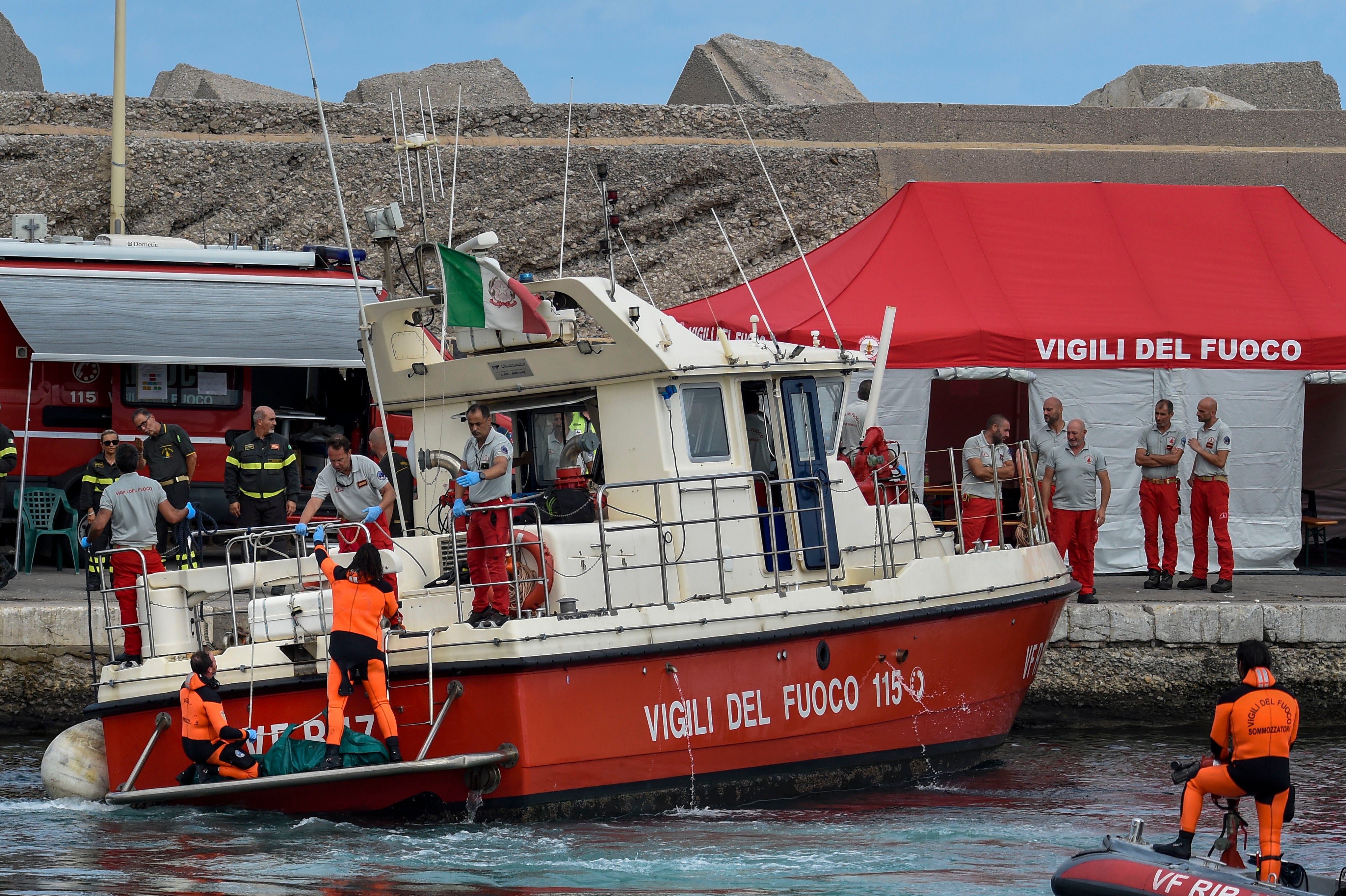 Itaiian rescue workers bringing a body bag to shore on Thursday morning