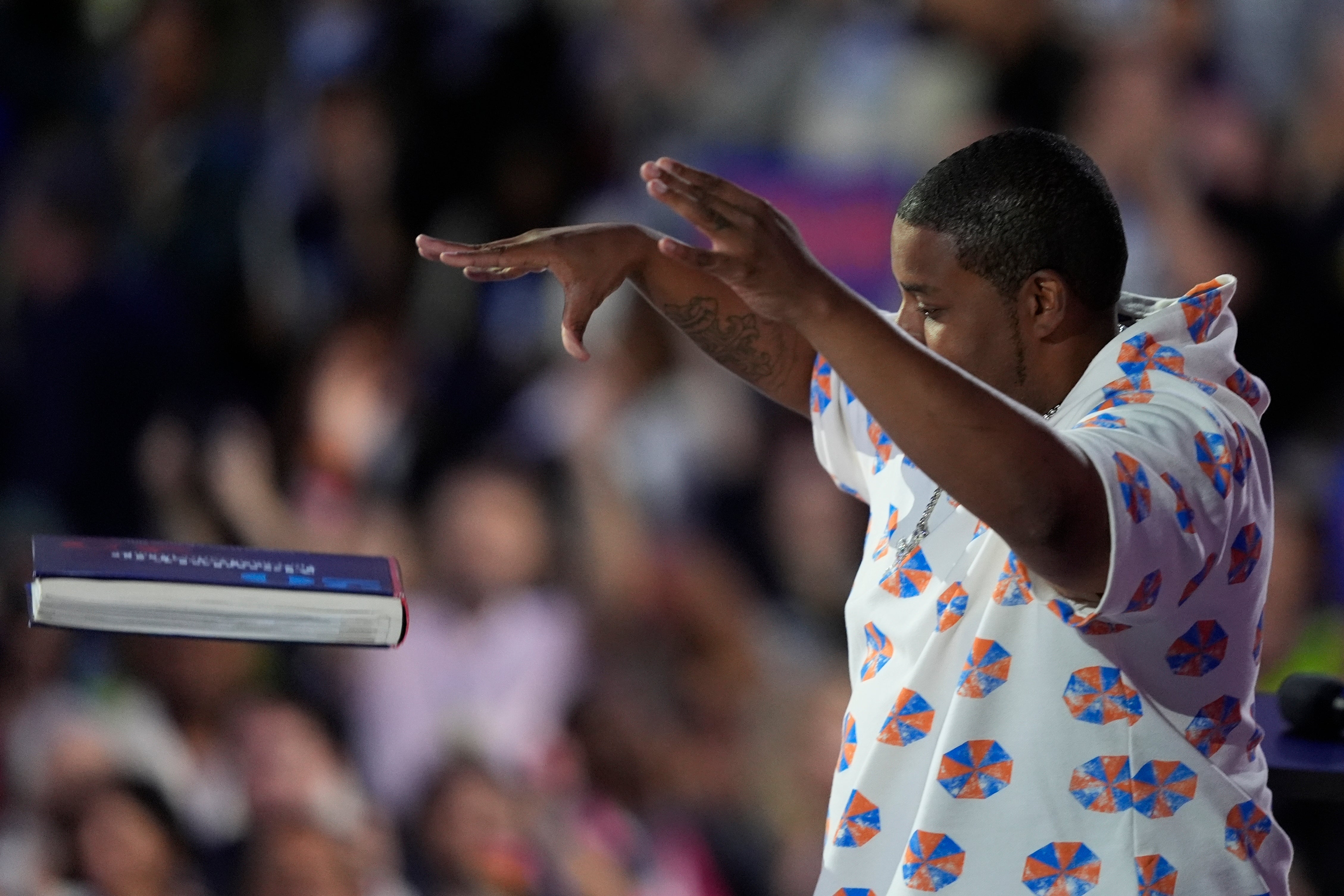 Kenan Thompson drops Project 2025 book in front him at the Democratic National Convention in Chicago