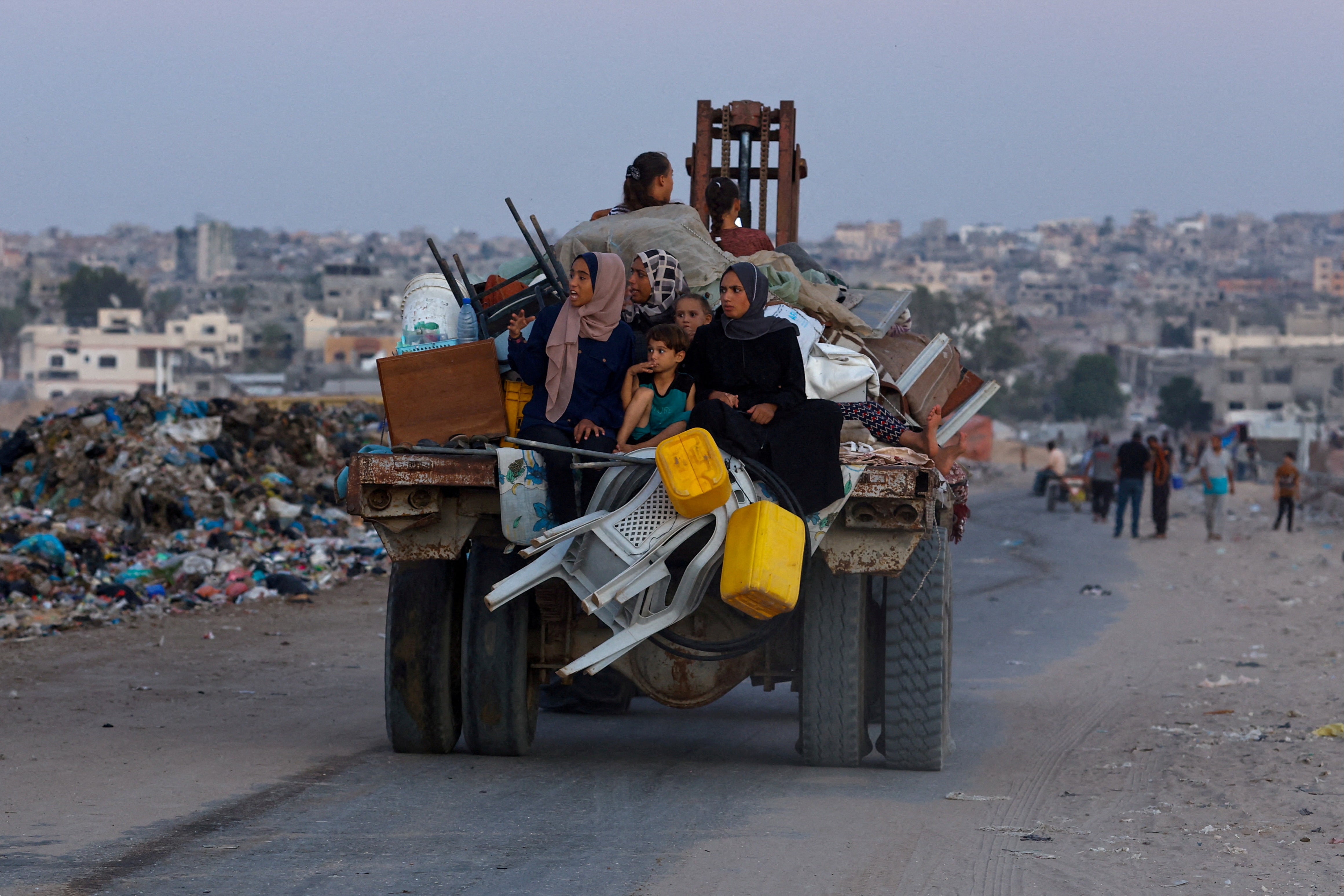 Displaced Palestinians travel on a cart after fleeing the western part of Khan Younis, following an evacuation order by the Israeli army