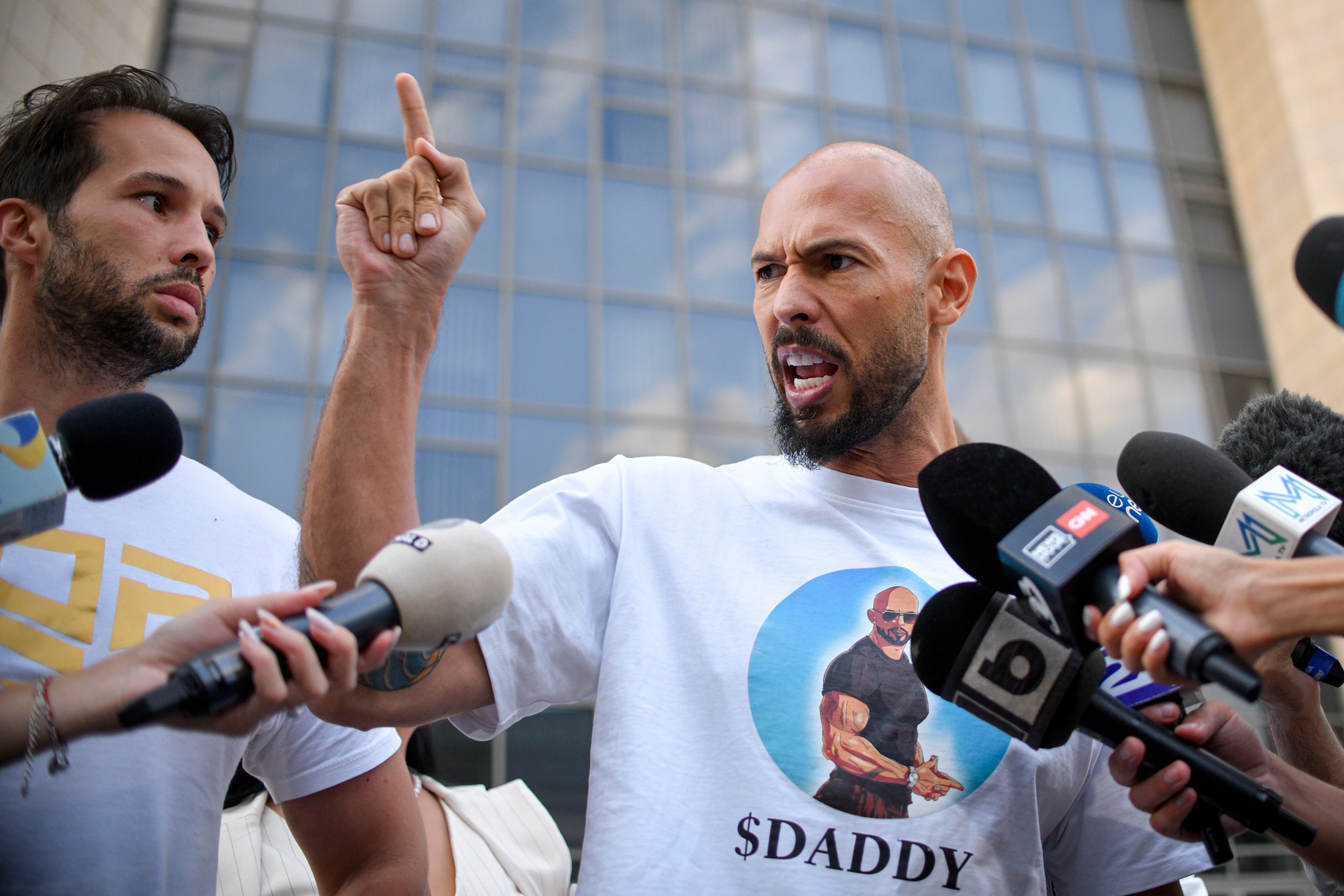 Andrew and his brother Tristan, left, speaking to the media in Bucharest, where he faces separate criminal charges