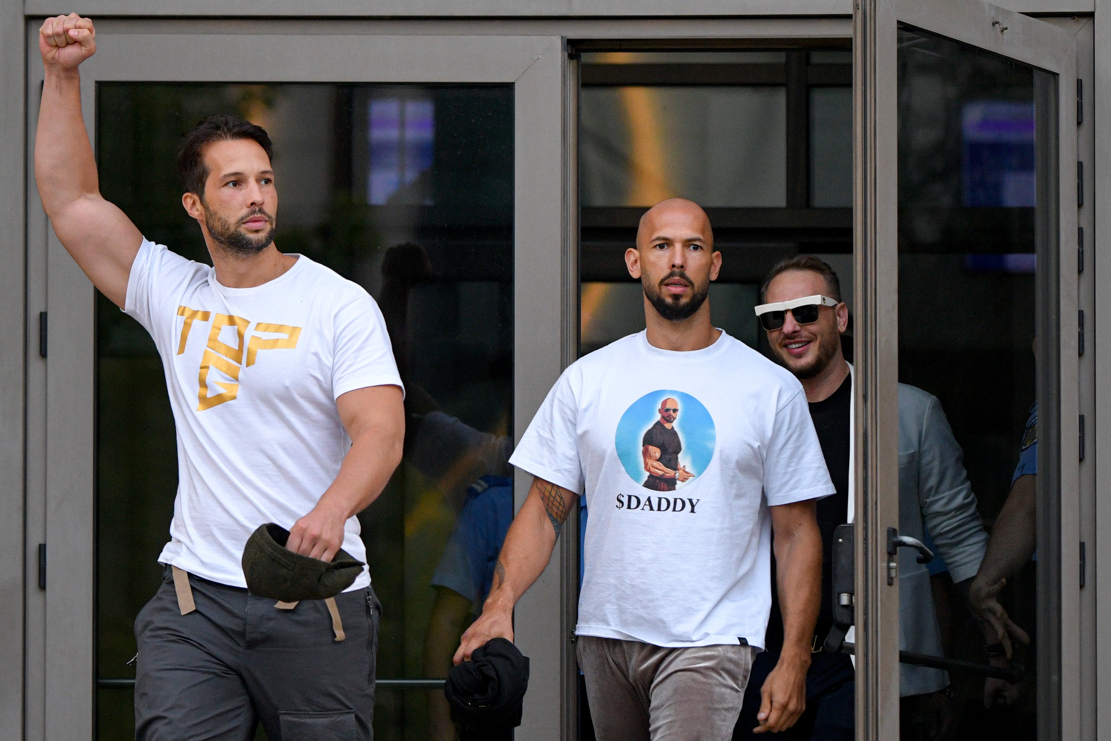 Andrew Tate, center, and his brother Tristan, left, exit the Bucharest Tribunal in August