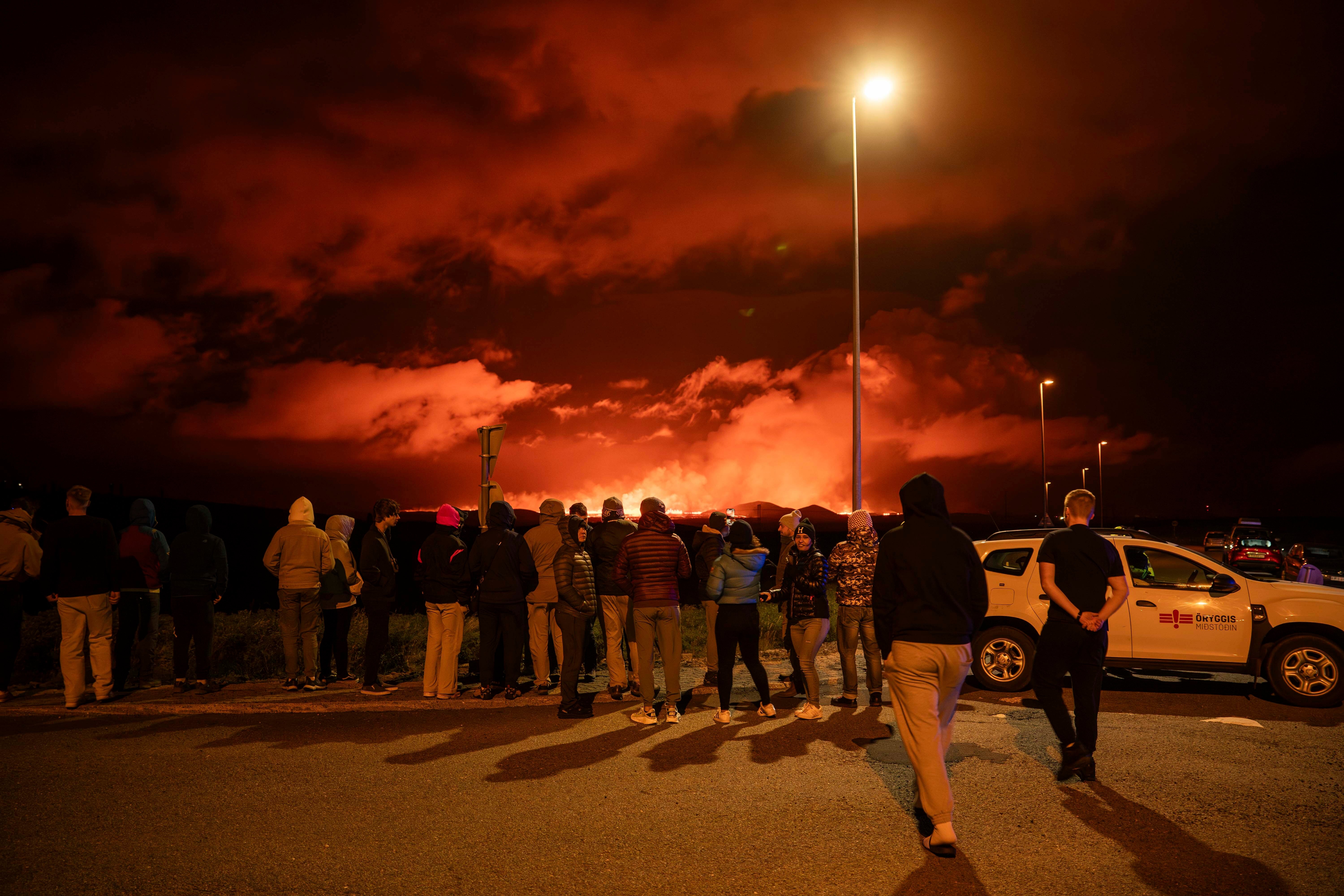 Tourists and visitors try to get a view of the eruption from a distance from the intersection between Reykjanesbraut, Iceland, and the road to Grindavik, Thursday, 22 August 2024