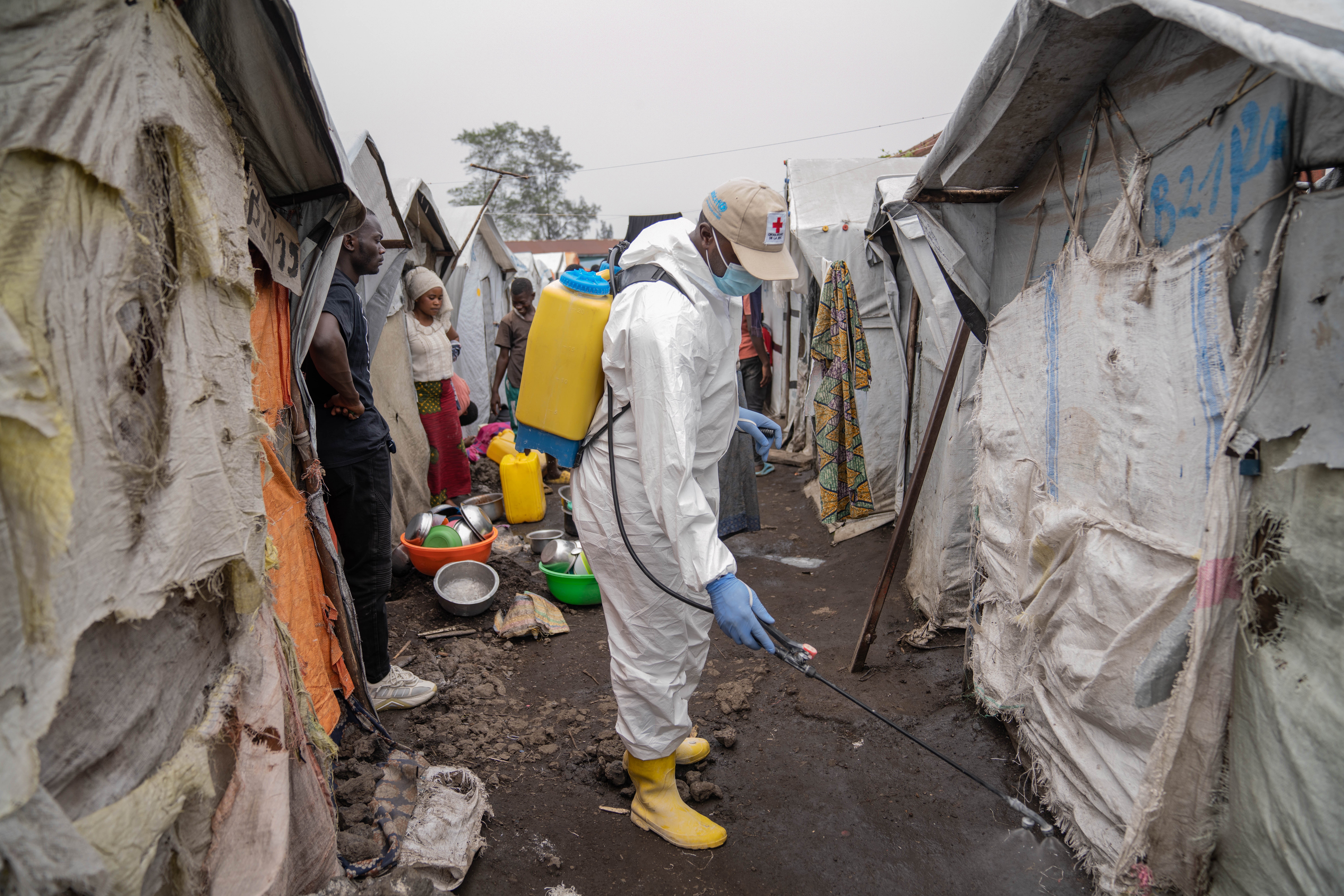 A Red Cross worker sprays chlorine as other Red Cross personnel raised awareness about mpox and hygiene among internally displaced people in the Don Bosco camps in Goma