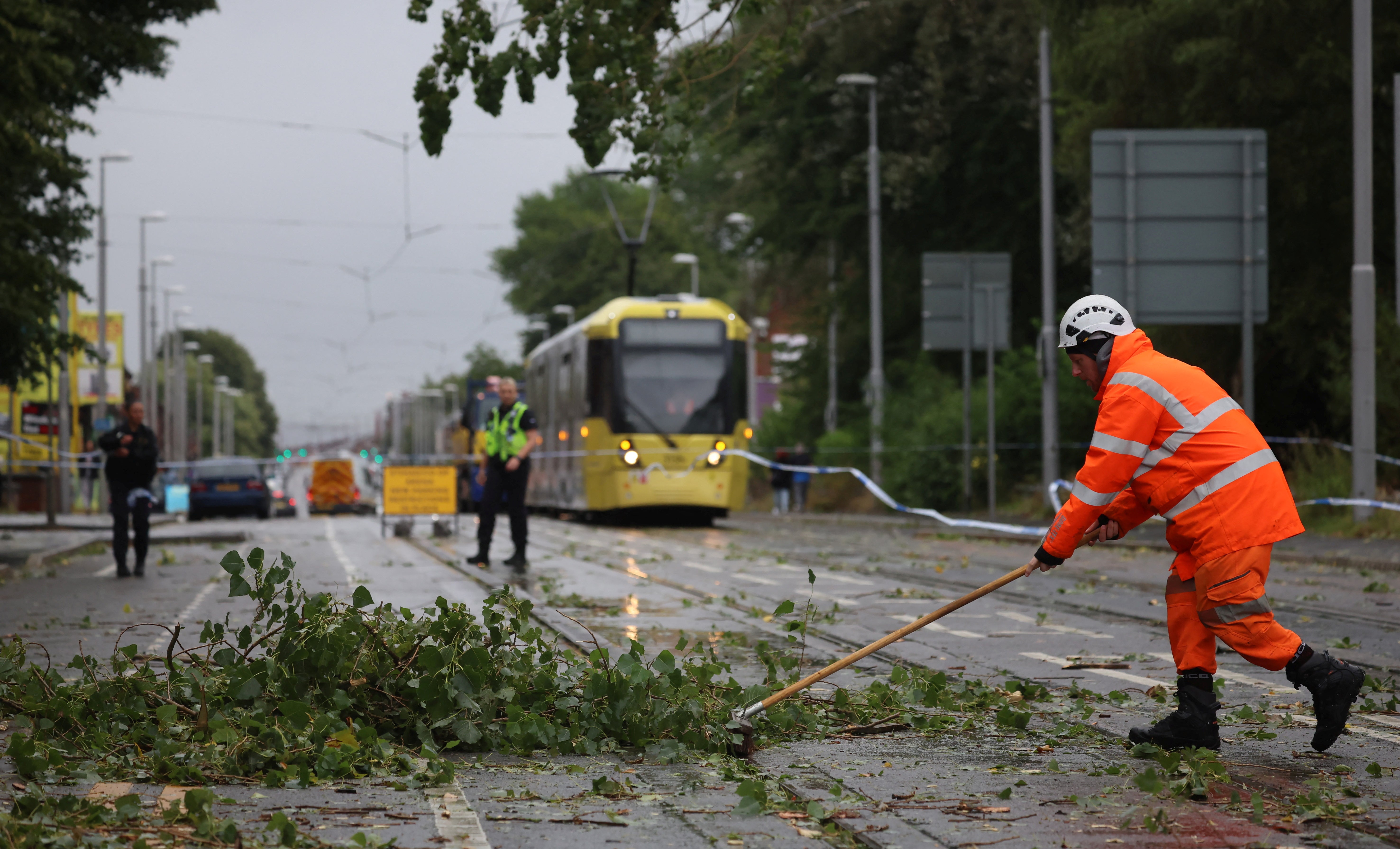 Workers begin to remove fallen tree branches after strong winds brought by Storm Lilian brought down trees blocking roads and tram routes in Manchester