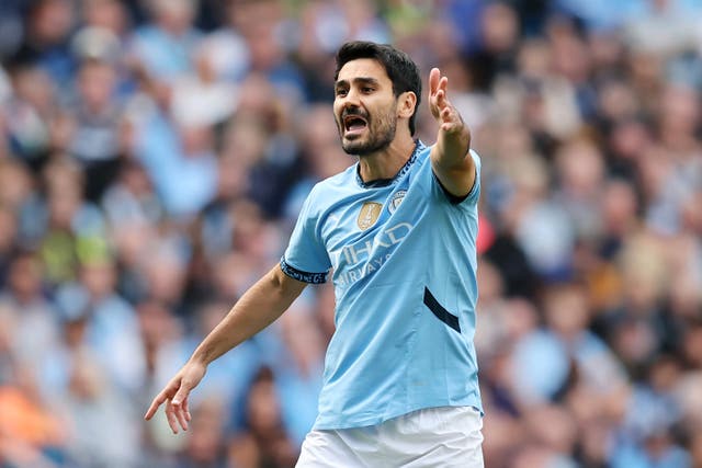 <p>Ilkay Gundogan directs the traffic on his return to the City side</p>