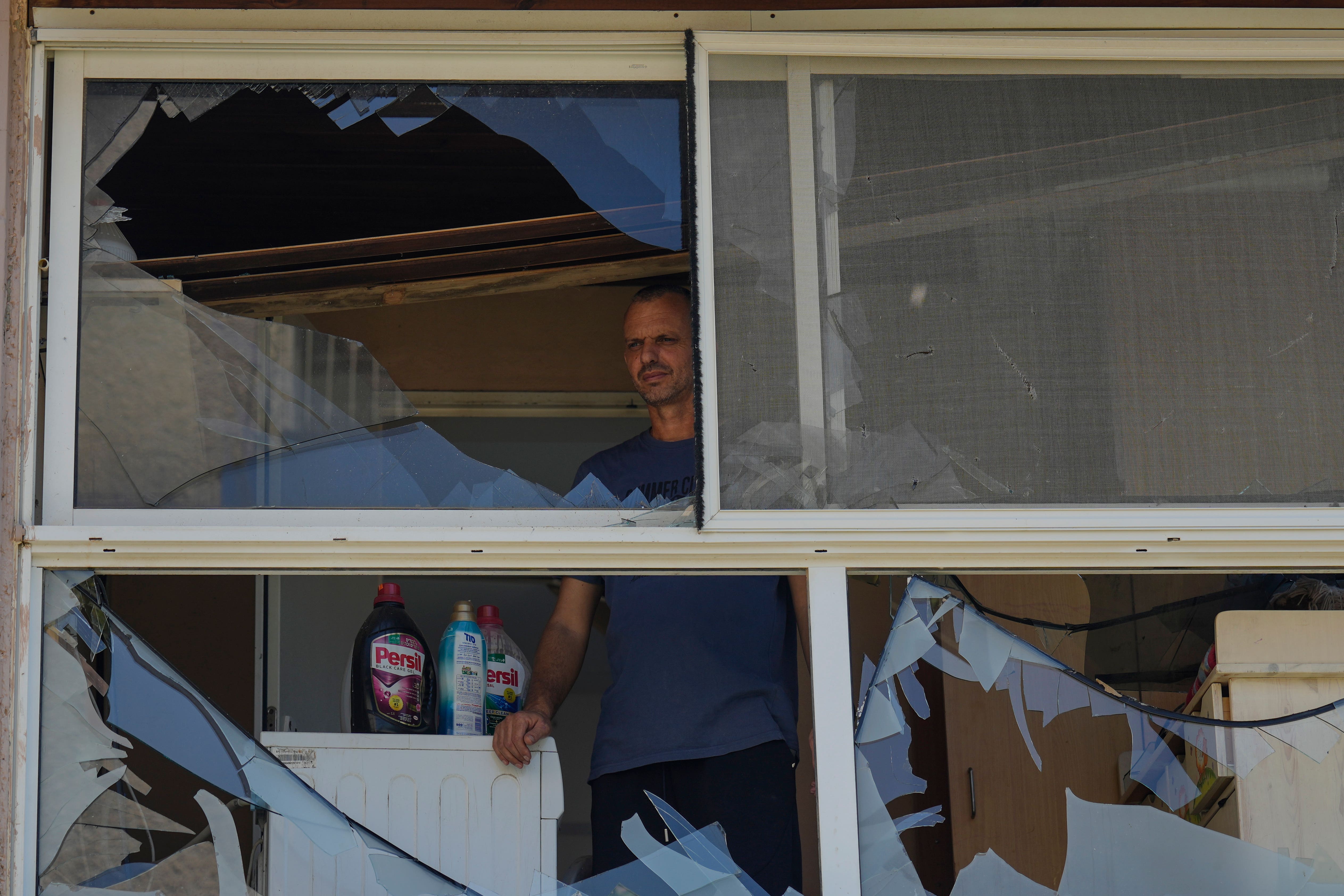 A man looks at a damaged window of a house following an attack from Lebanon, in Acre, north Israel (Ariel Schalit/AP)