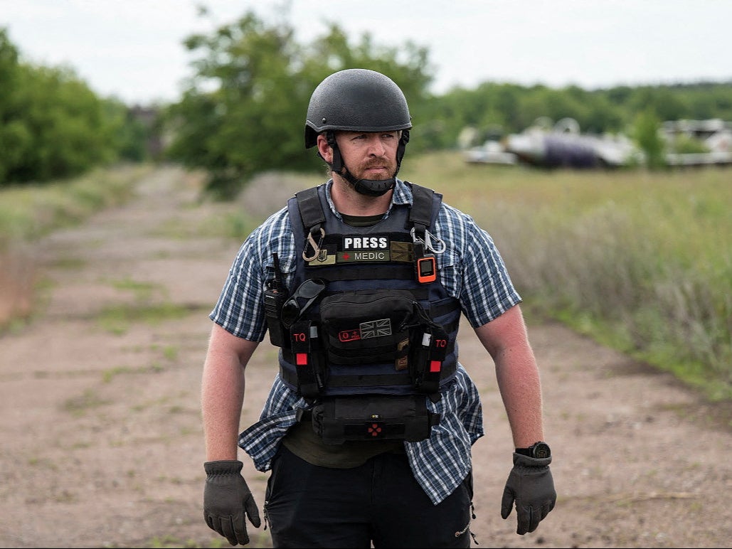 Reuters safety adviser Ryan Evans stands in a field while working with a news reporting team in an undated photo taken in Ukraine