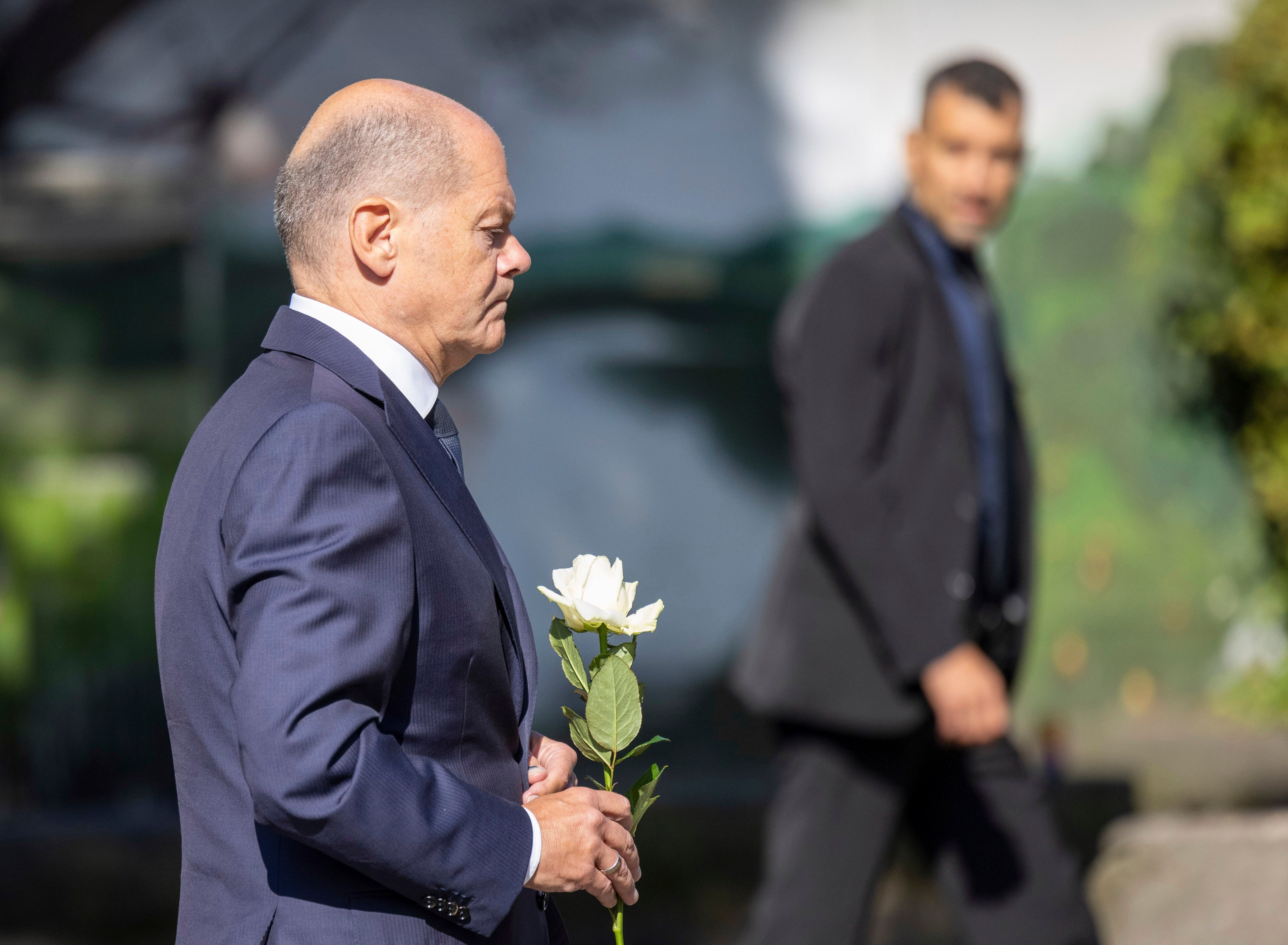 Germany Chancellor Olaf Scholz lays a flower at a church, near the scene of a knife attack, in Solingen, Germany