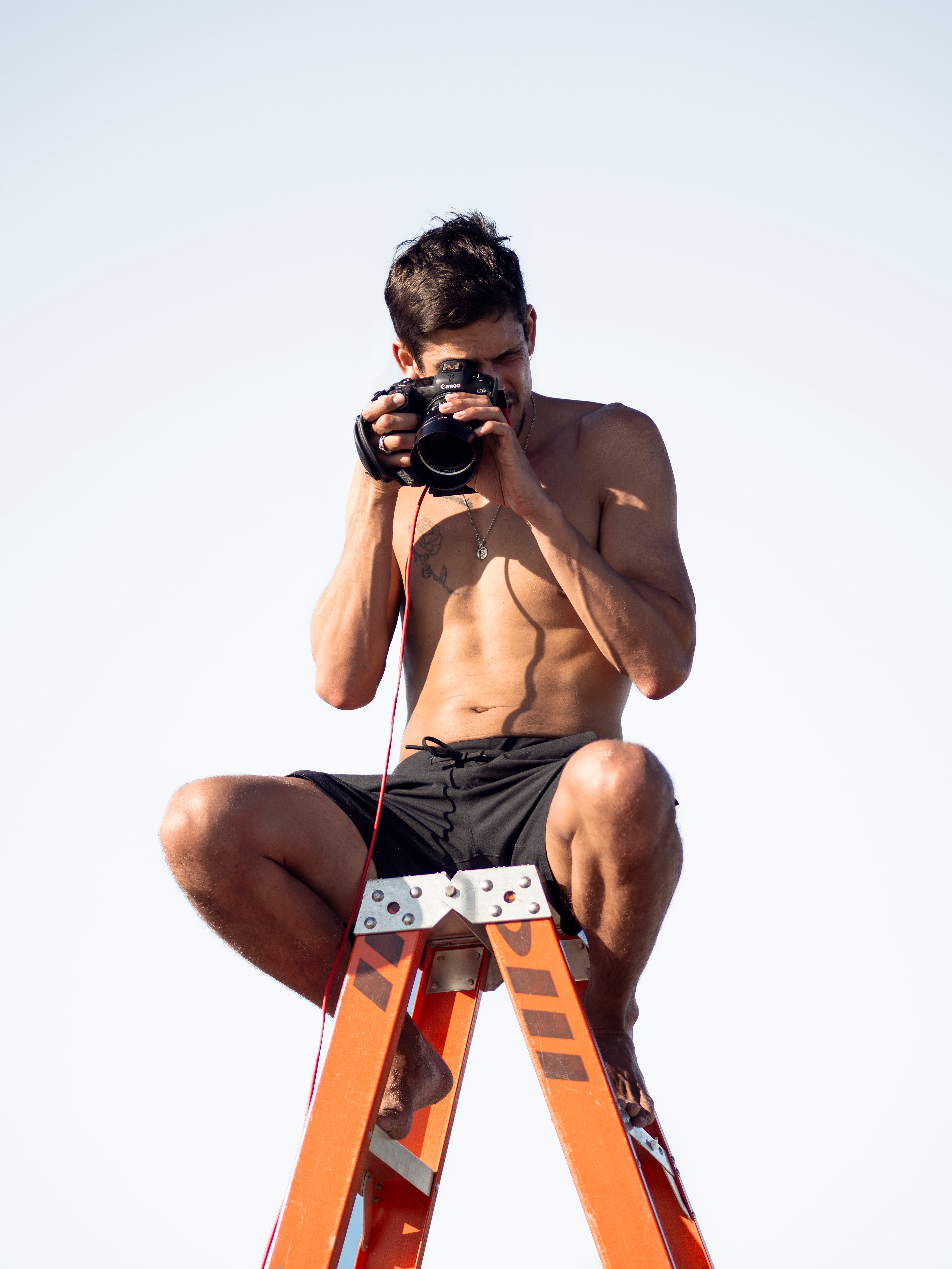 Ethan James Green balances on a ladder for Simone Ashley’s 2025 Pirelli Calendar shoot