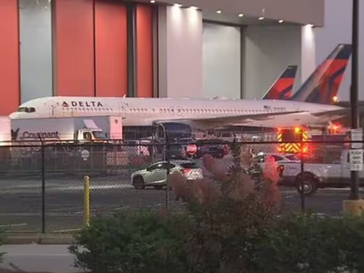 Emergency vehicles seen parked near a Delta plane at the Hartsfield-Jackson Atlanta International Airport. A tire on a Delta plane exploded, killing two Delta employees and injuring a third