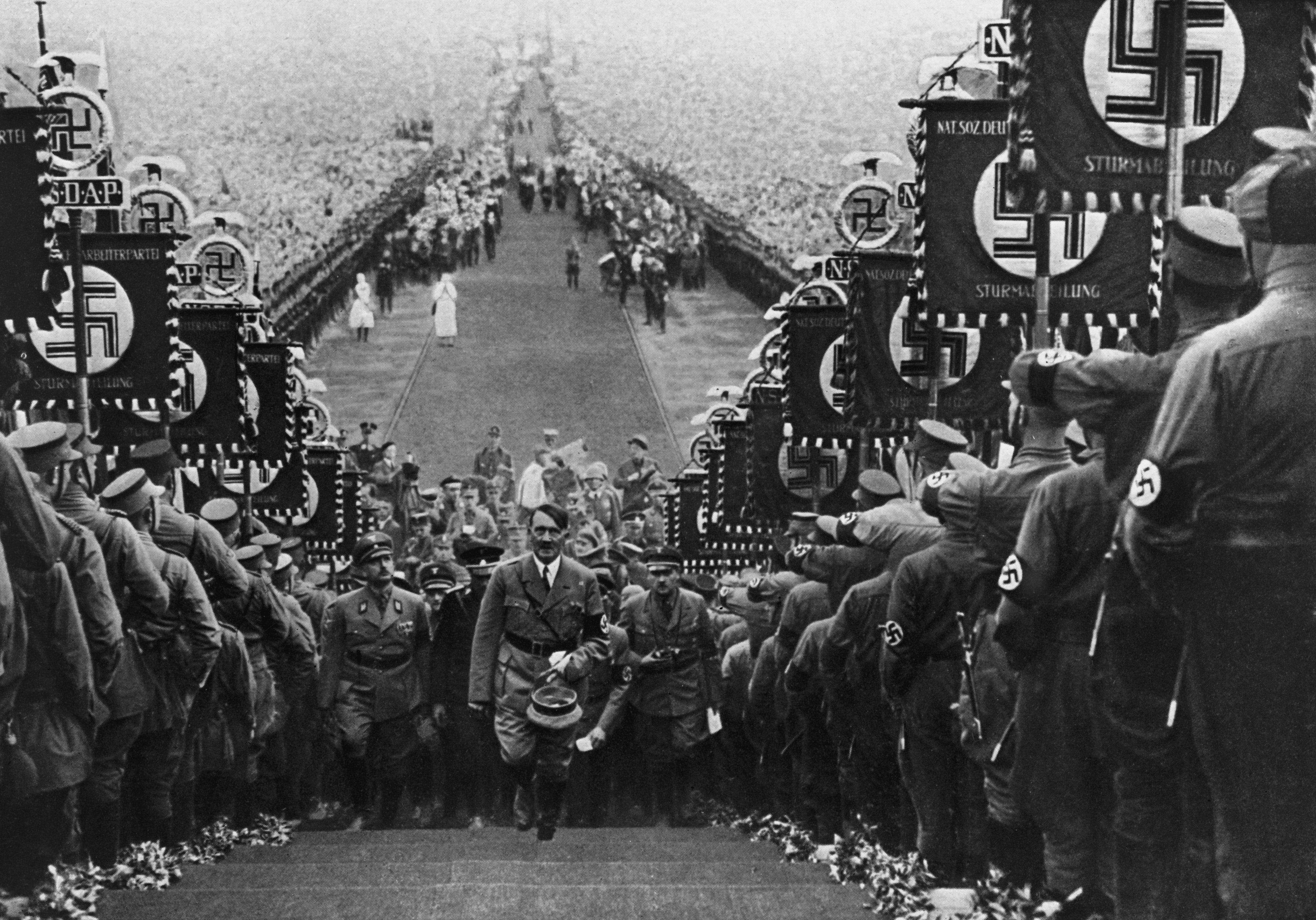 Adolf Hitler ascending the steps at Buckeberg flanked by banner-carrying storm troopers