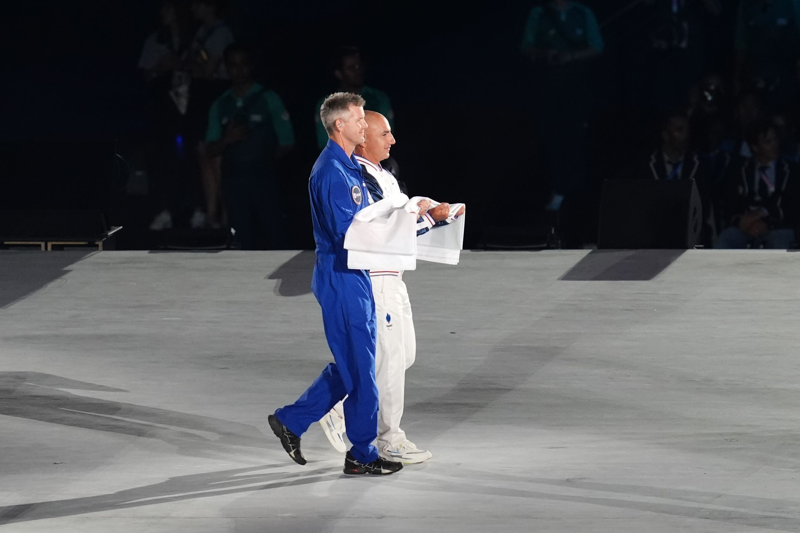 The Paralympic flag is carried on stage by John McFall (left) during the opening ceremony of the Paris 2024 Games (Adam Davy/PA)