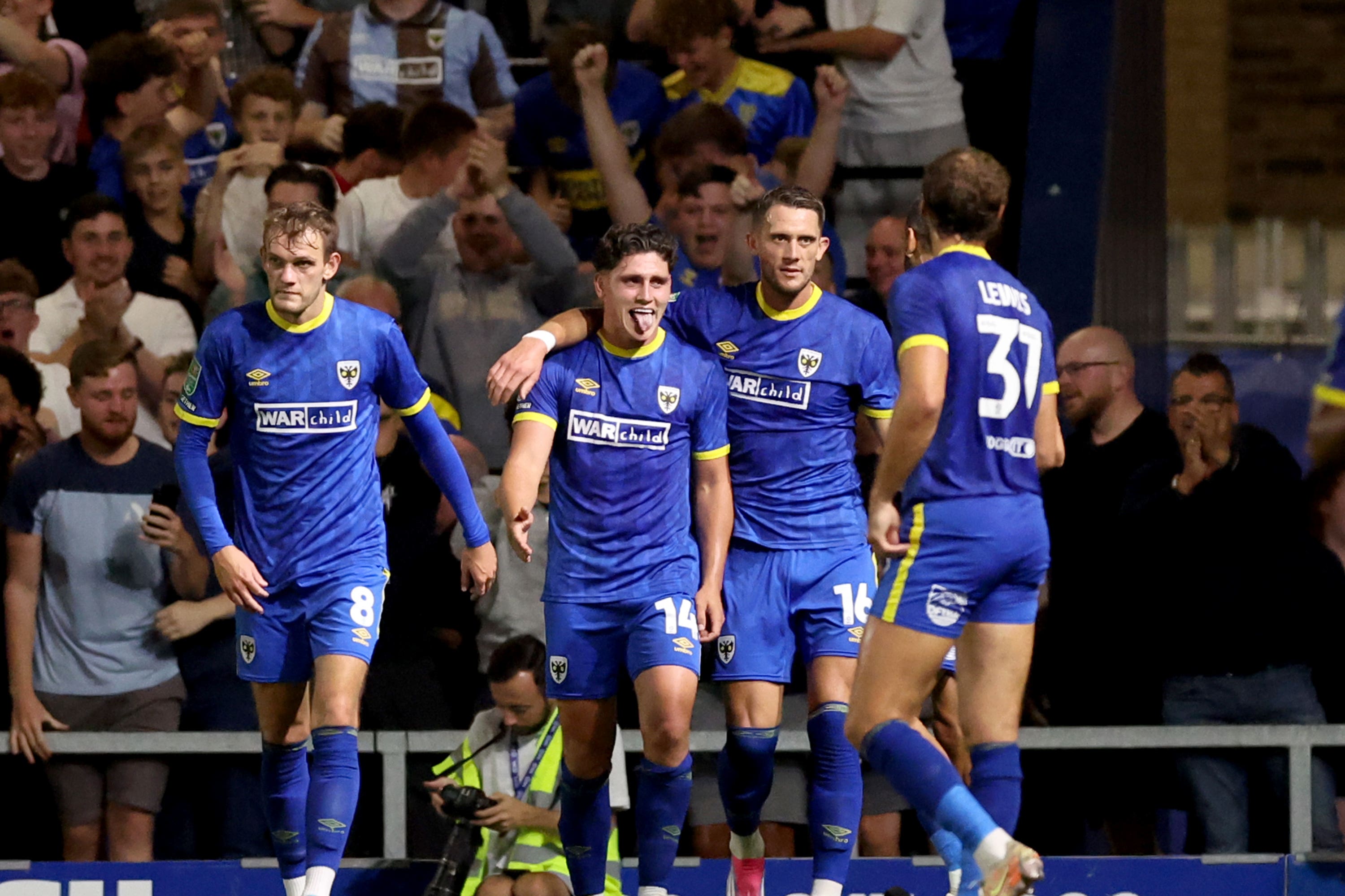 Mathew Stevens (centre) celebrates scoring AFC Wimbledon’s second (Steven Paston/PA)