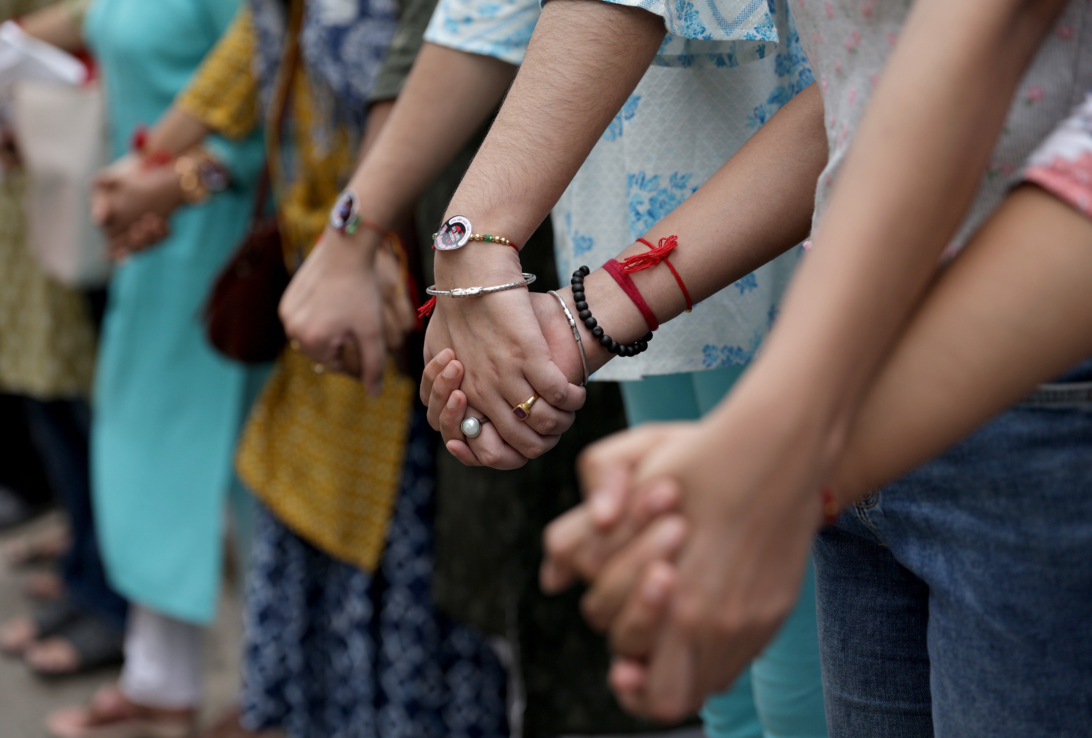 Medical students and doctors make a human chain during a protest as they demand justice