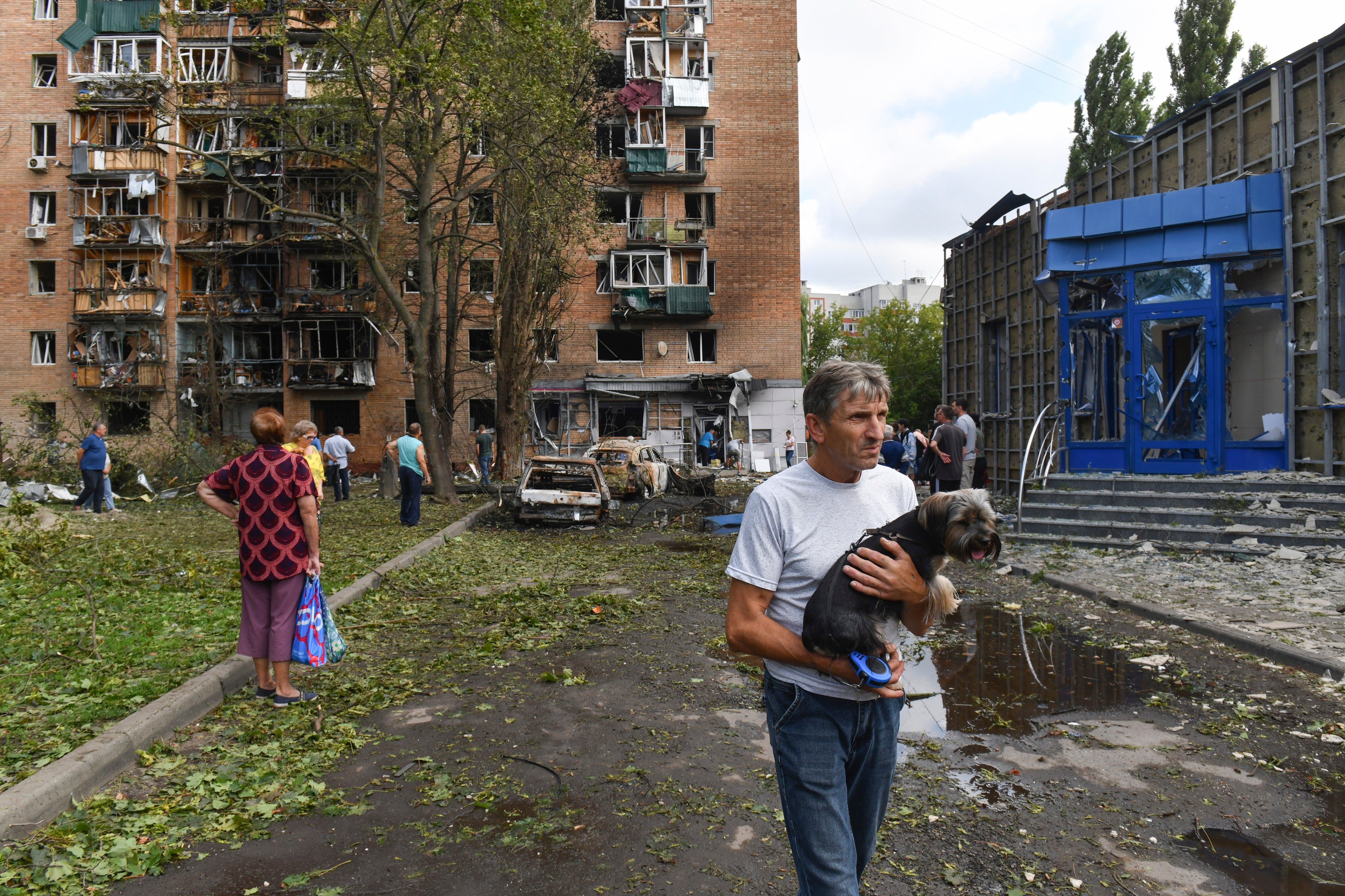 Residents leave an apartment building damaged in shelling by Ukrainian forces in Kursk