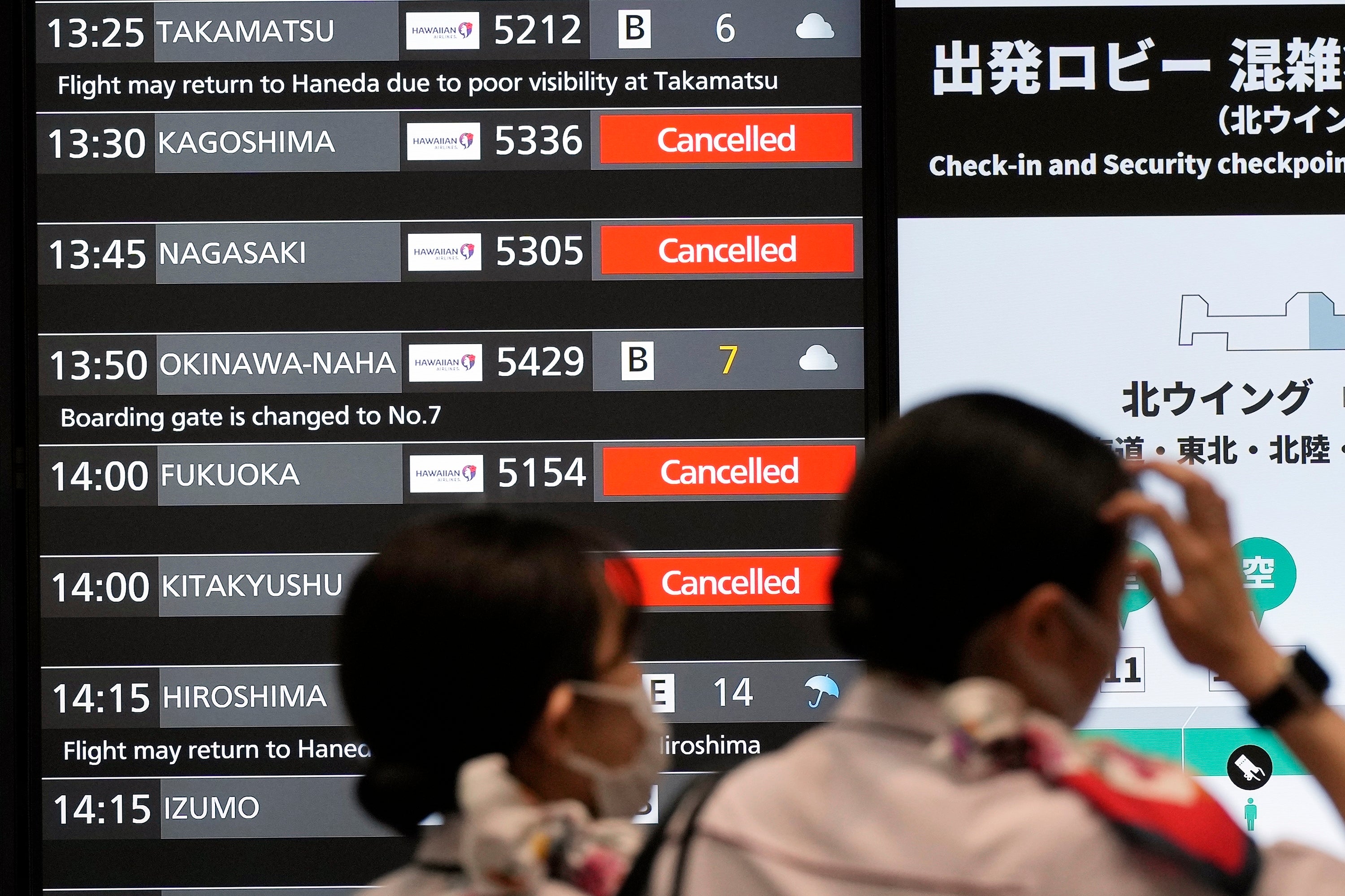 A departures board at Haneda airport shows flights cancelled because of the approaching storm