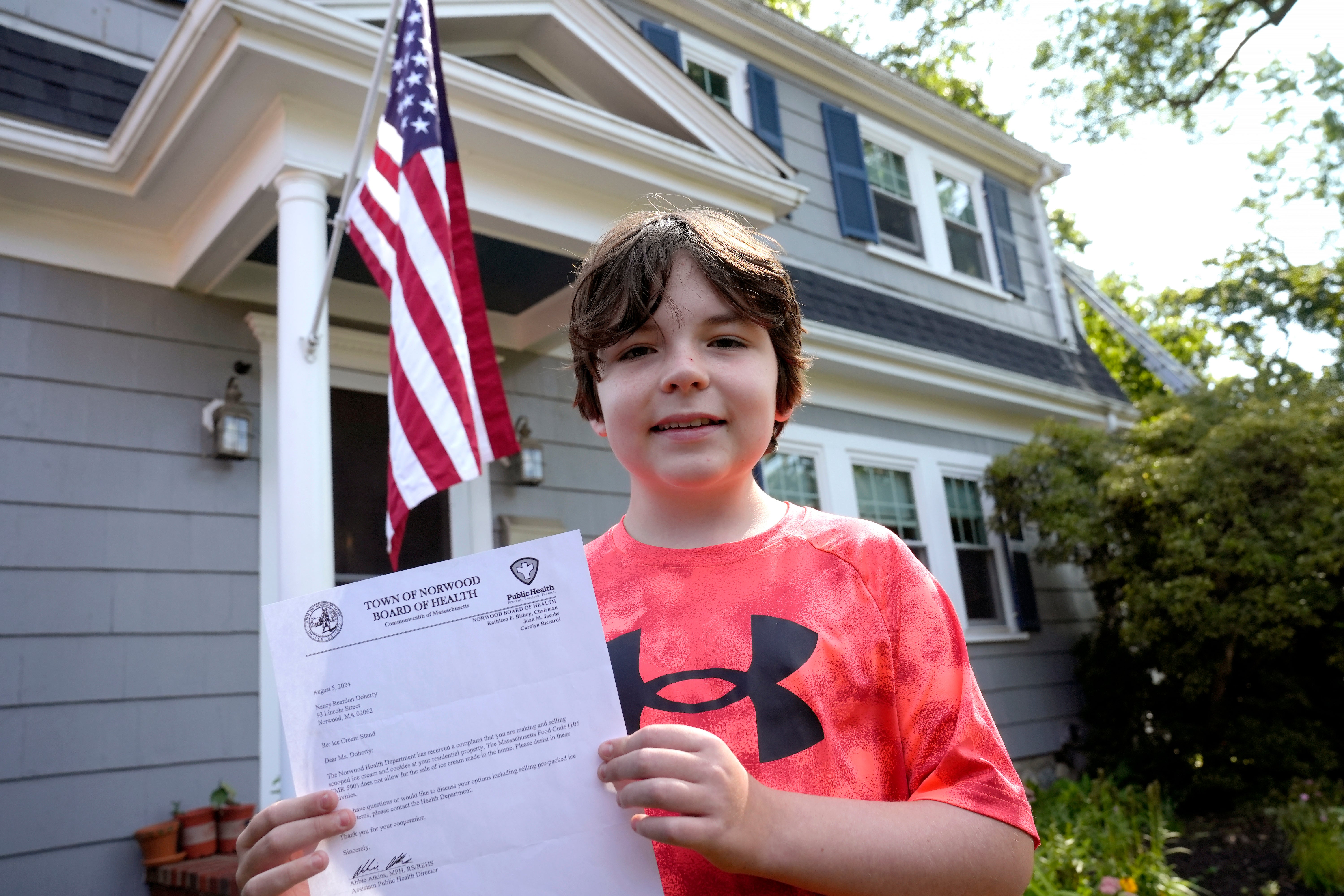 Danny Doherty, 12, holds a letter from the Town of Norwood Board of Health warning his family that they may not sell homemade ice cream at an ice cream stand due to a potential state food code violation