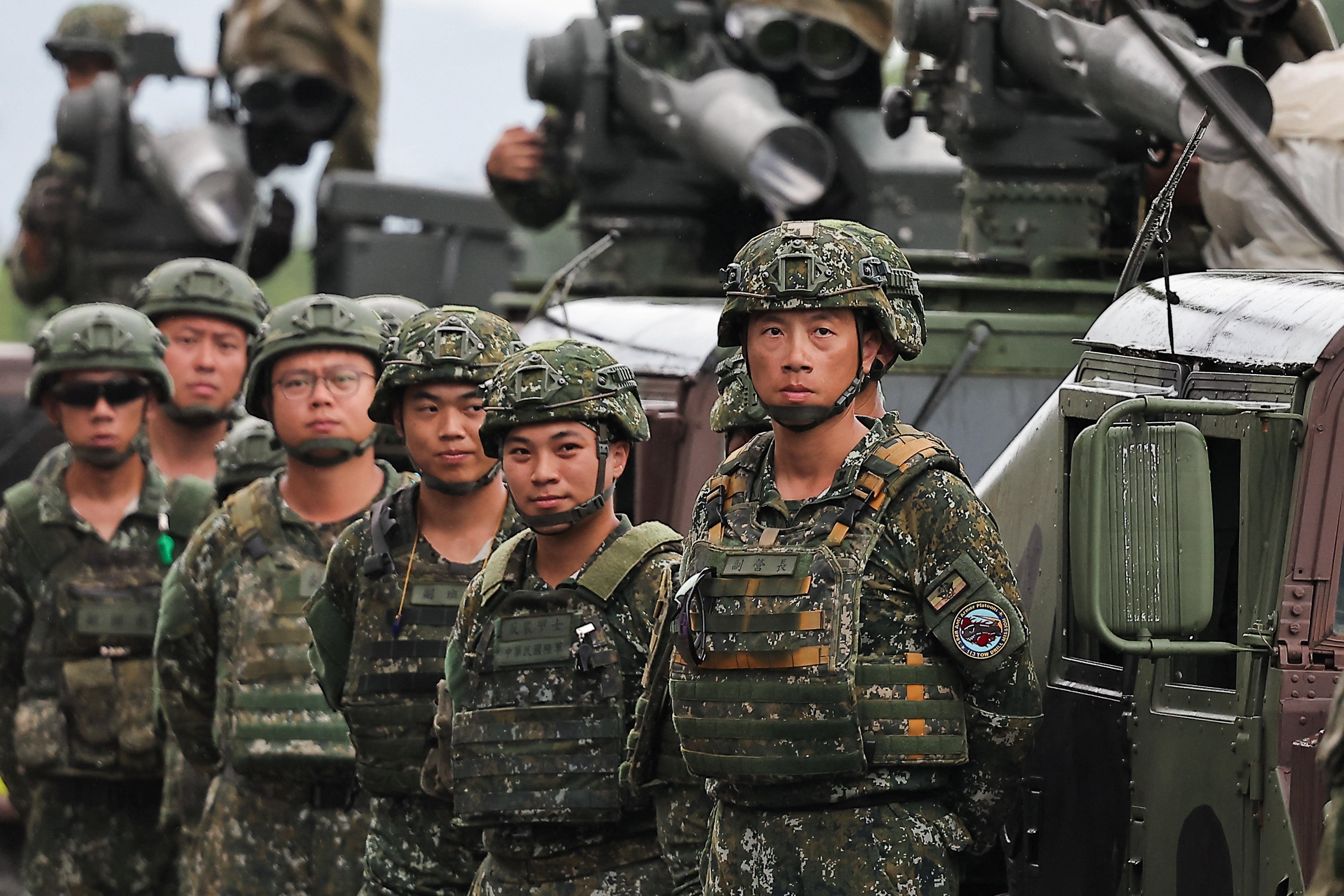 Taiwanese soldiers stand next to an armoured vehicle in Pingtung County