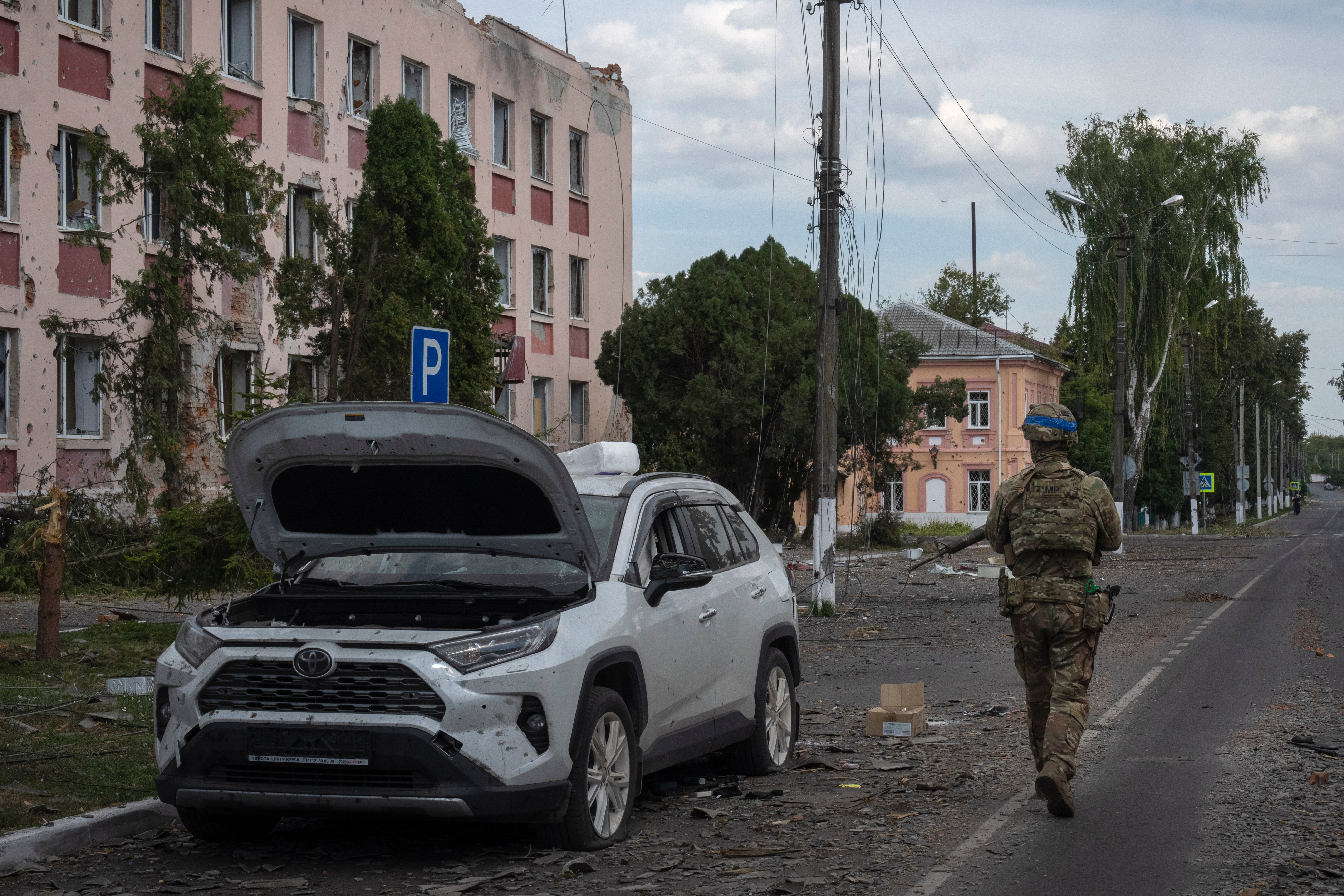 A Ukrainian soldier walks past at a city hall in Sudzha