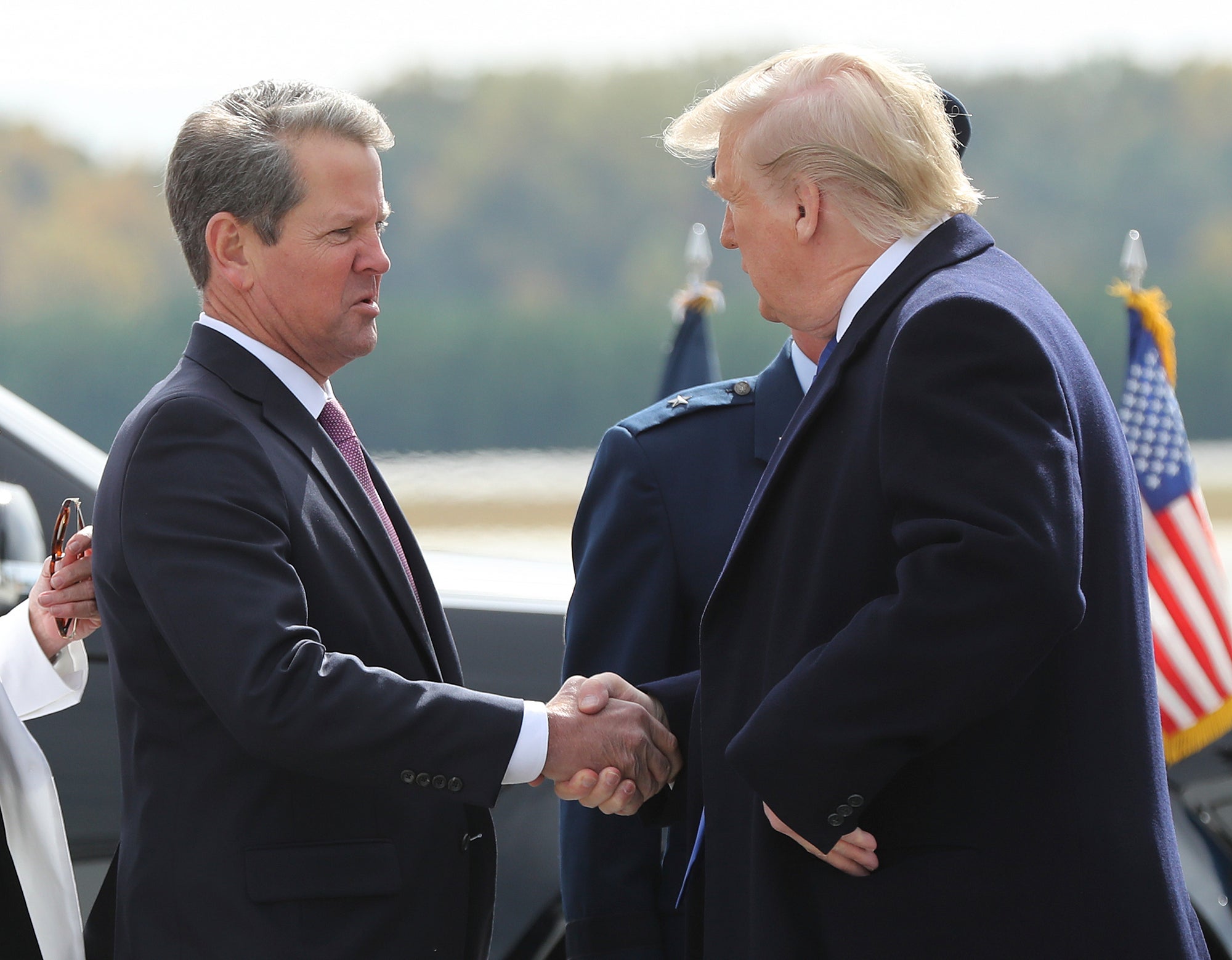 Georgia’s Governor Brian Kemp, pictured greeting Donald Trump in 2019, is asking whether he has authority to take action after ethics complaints to the state’s election board