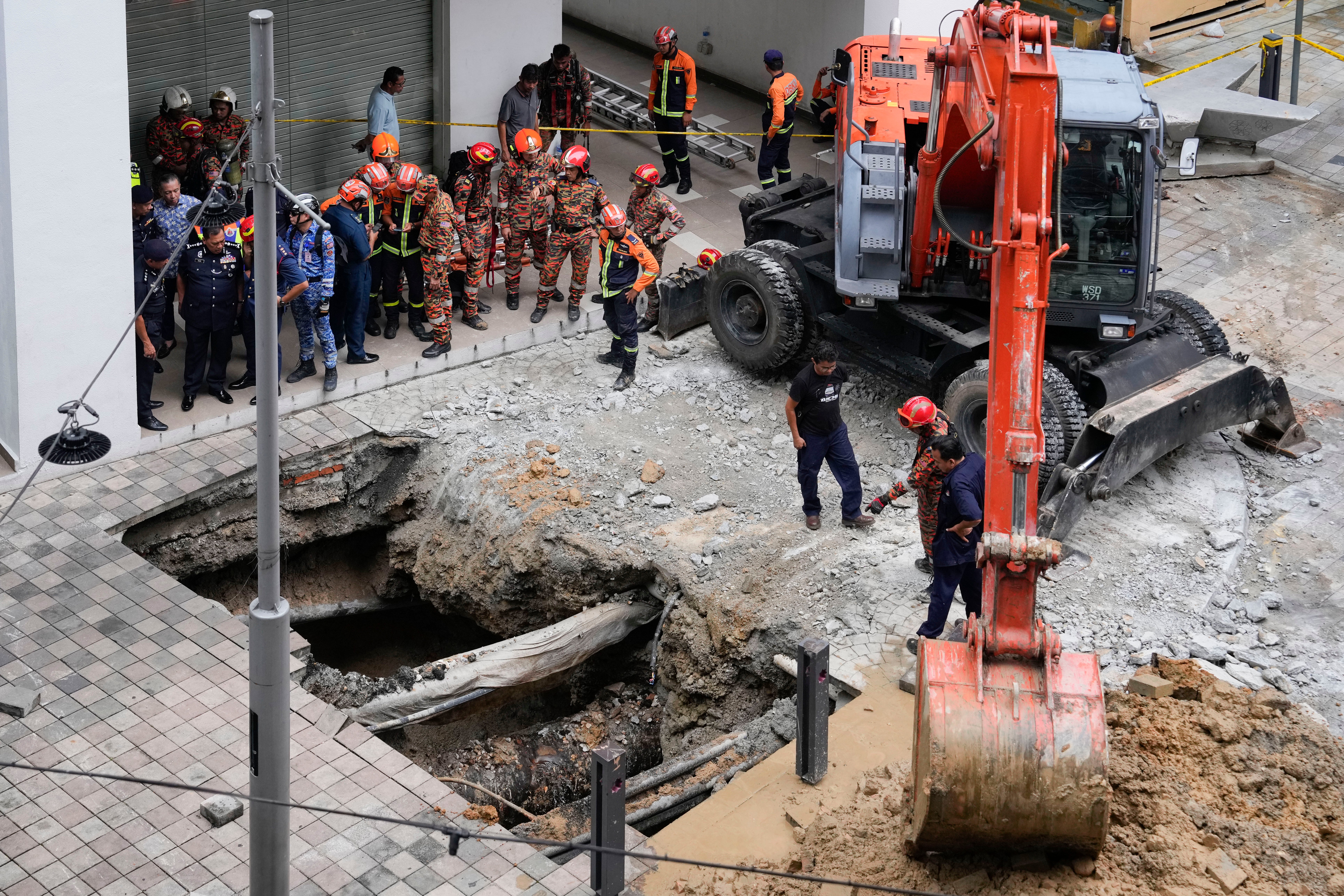 Fire and rescue department carry out search operations after a woman fell into a sinkhole in Kuala Lumpur on 23 August