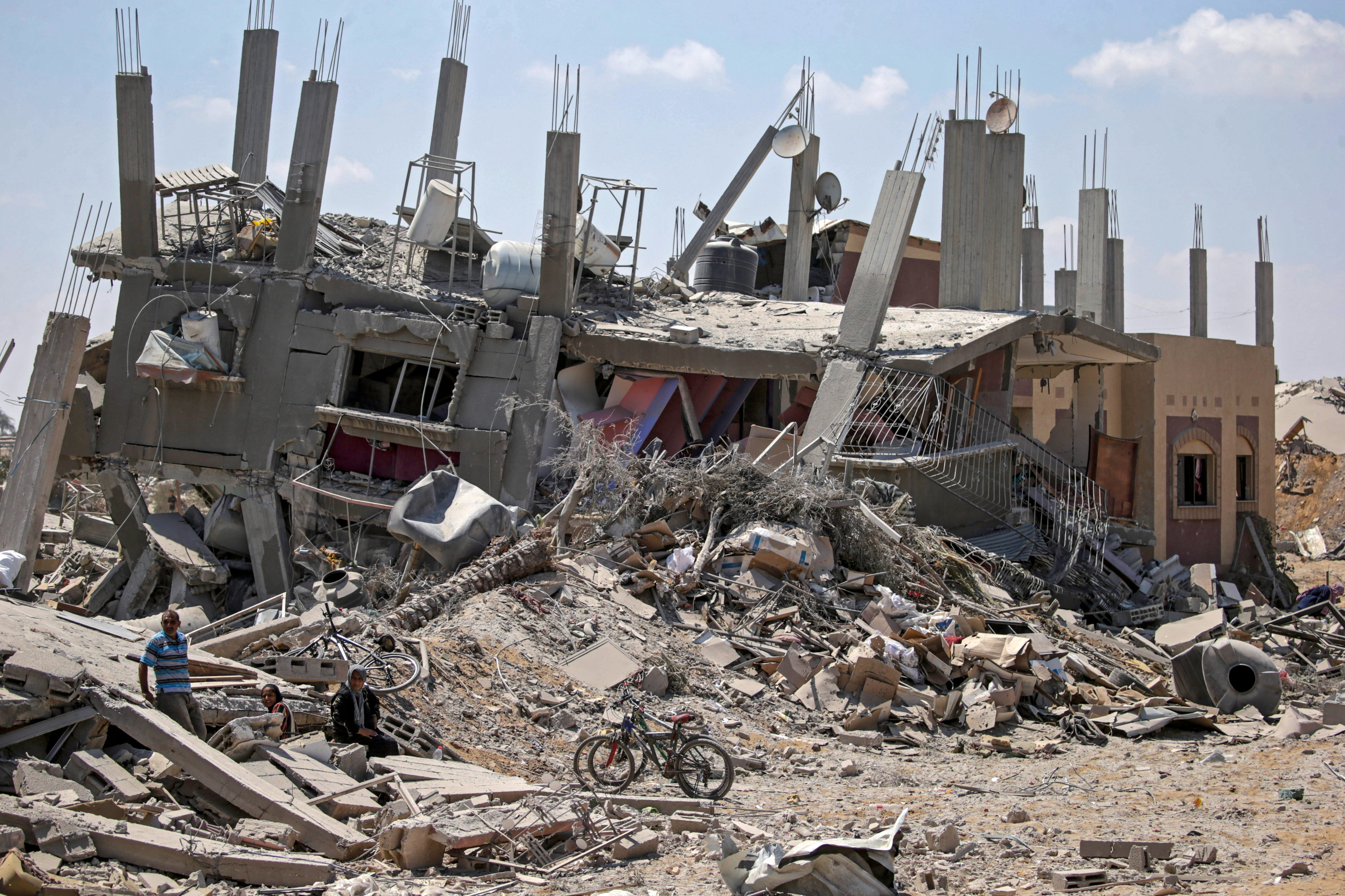 Internally displaced Palestinians inspect their destroyed houses as they return to Deir Al Balah town after the Israeli military pulled out troops from the east central Gaza Strip, 29 August 2024