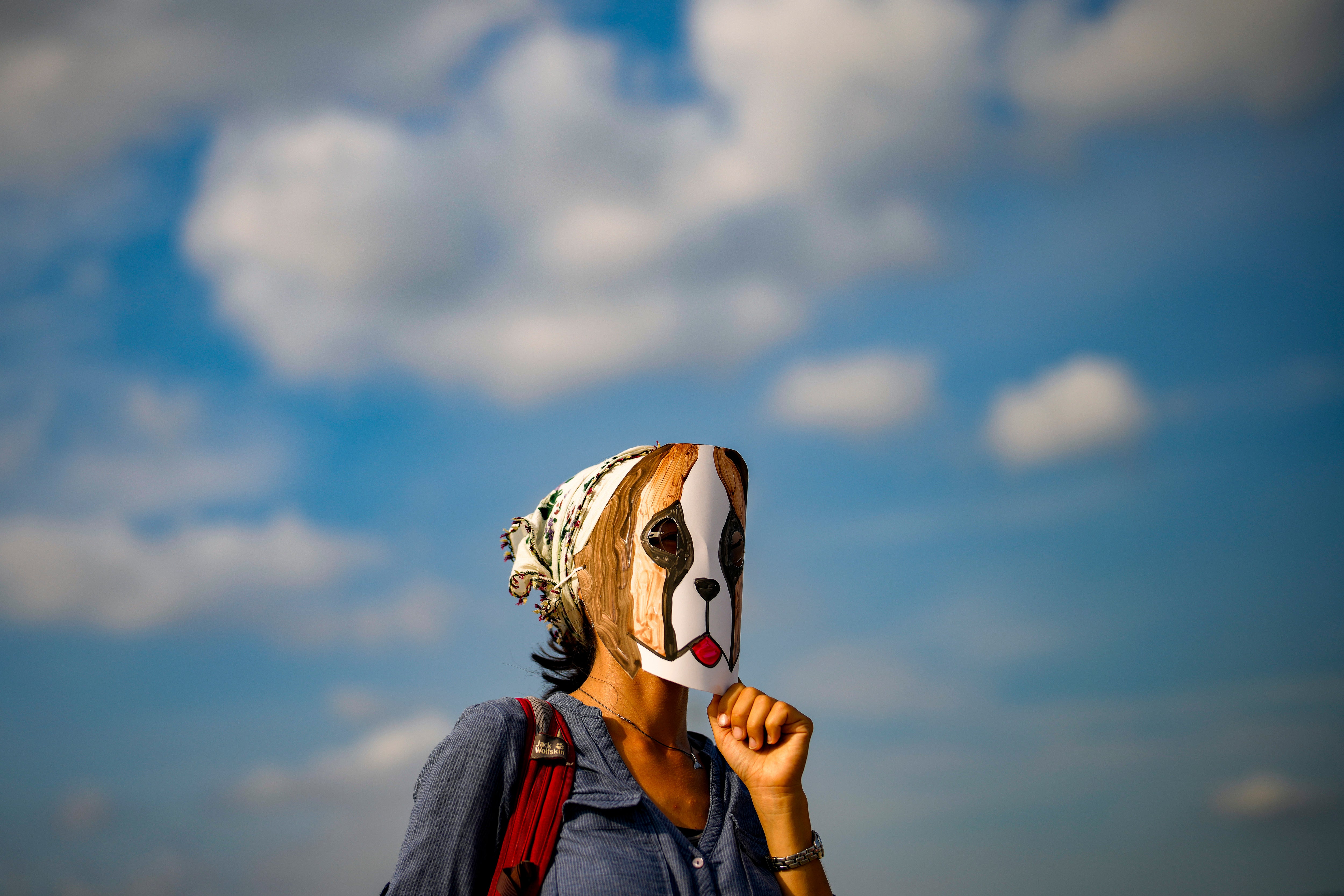 A woman wears a mask during a protest against a bill approved by Turkish legislators that aims to remove stray dogs