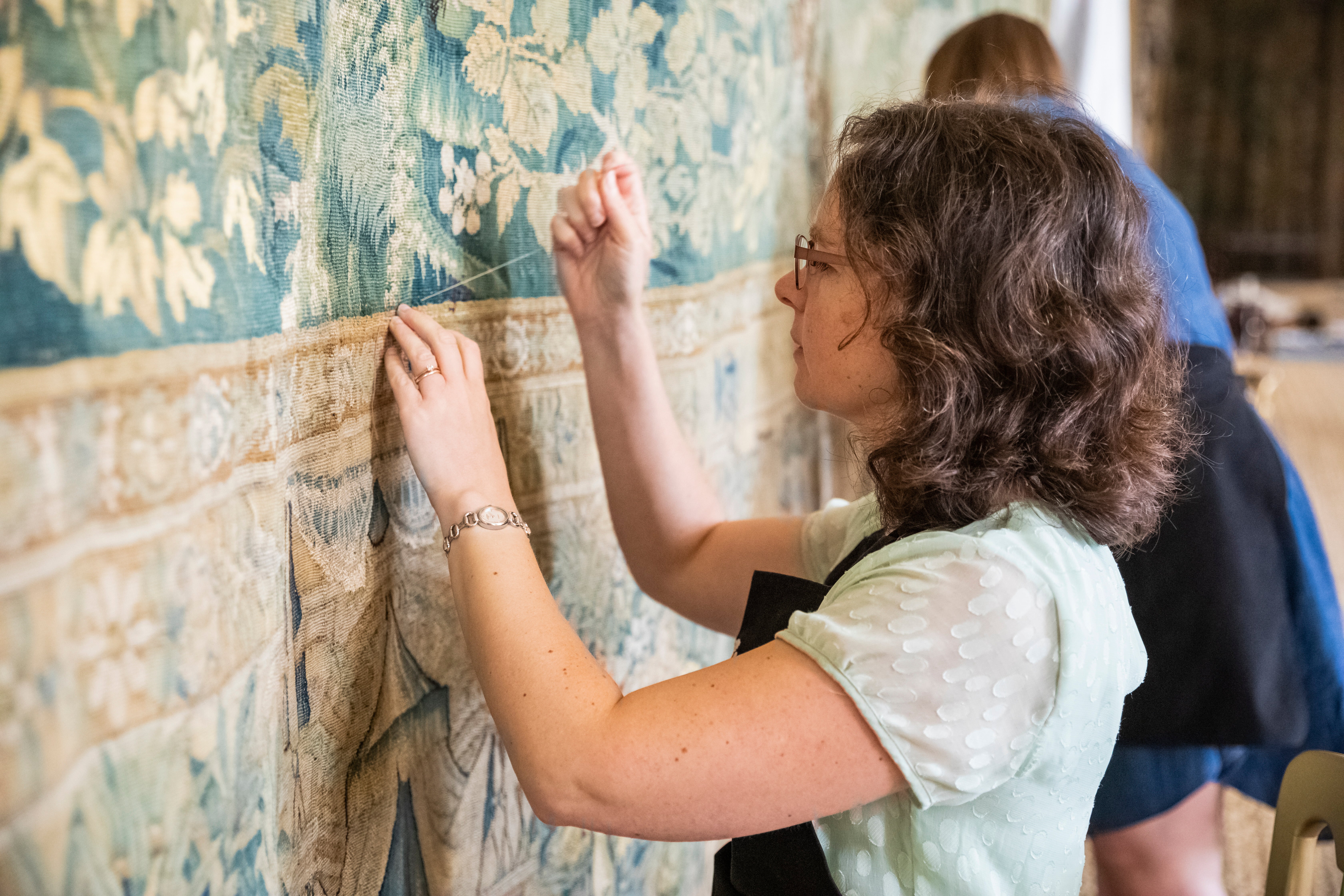 Staff make final adjustments to the tapestries at Hardwick Hall, Derbyshire