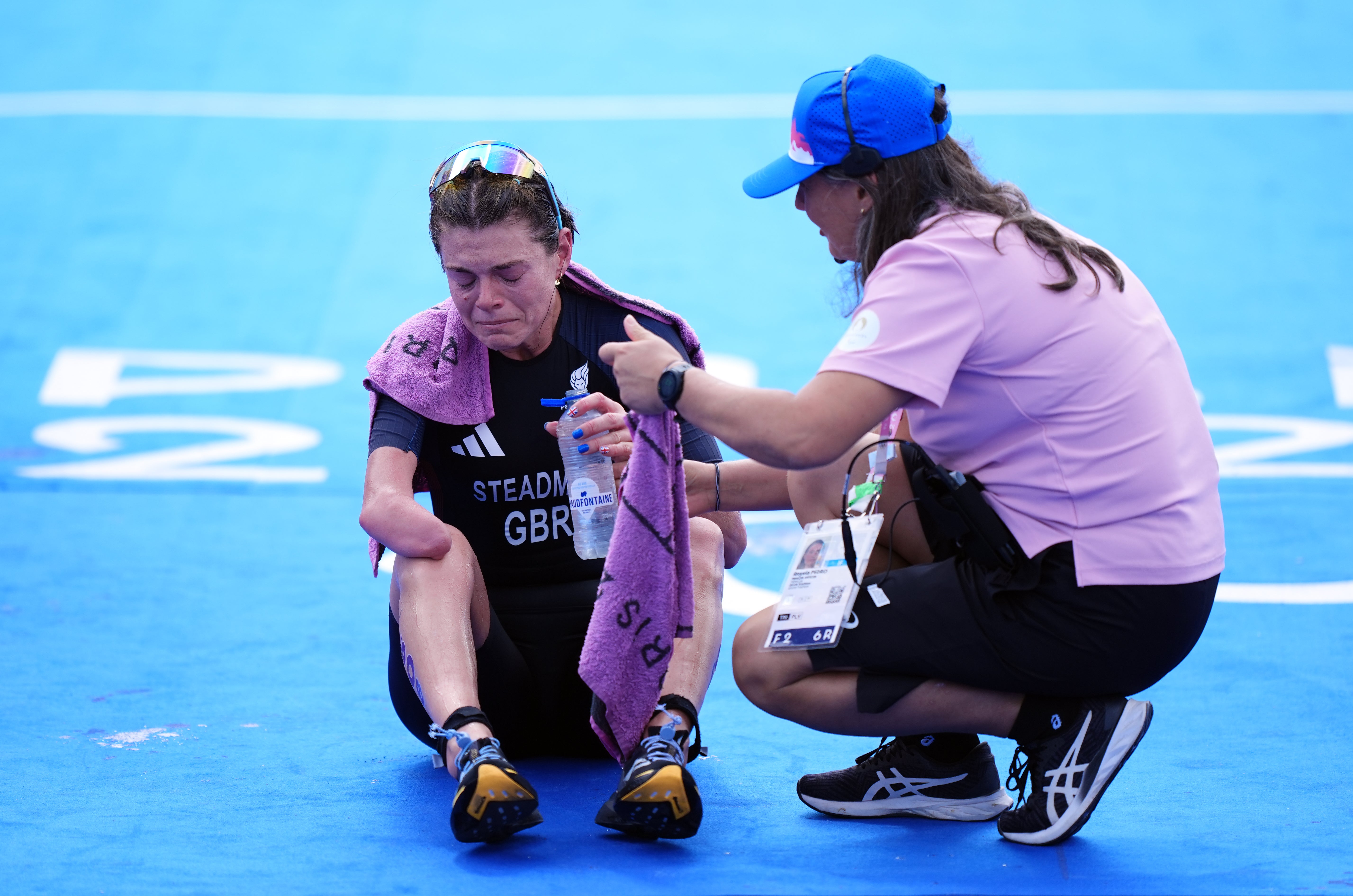 Lauren Steadman is helped after crossing the finish line