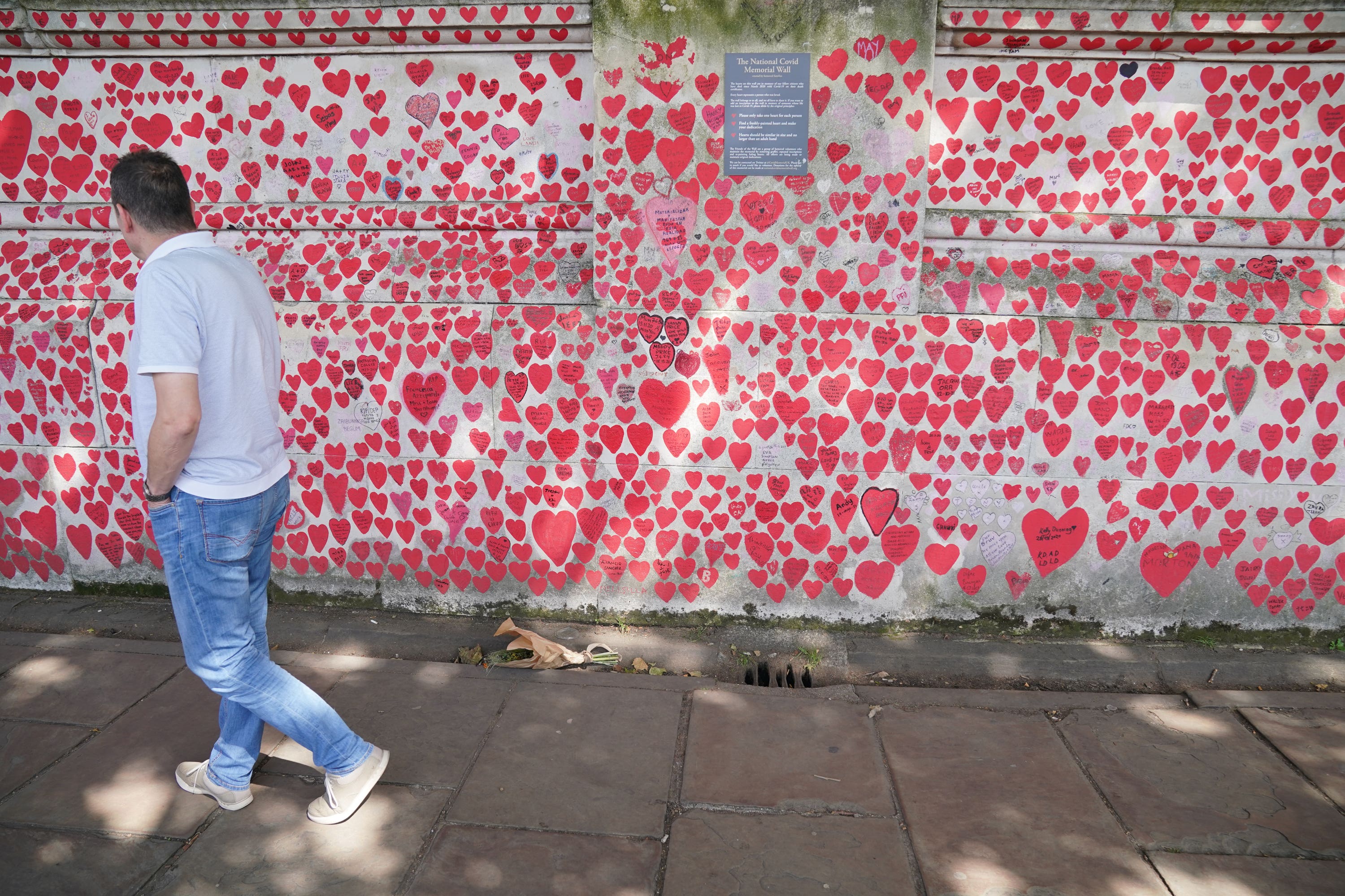 A man looks at the hearts as he walks along the Covid Memorial Wall in London (Jonathan Brady/PA)