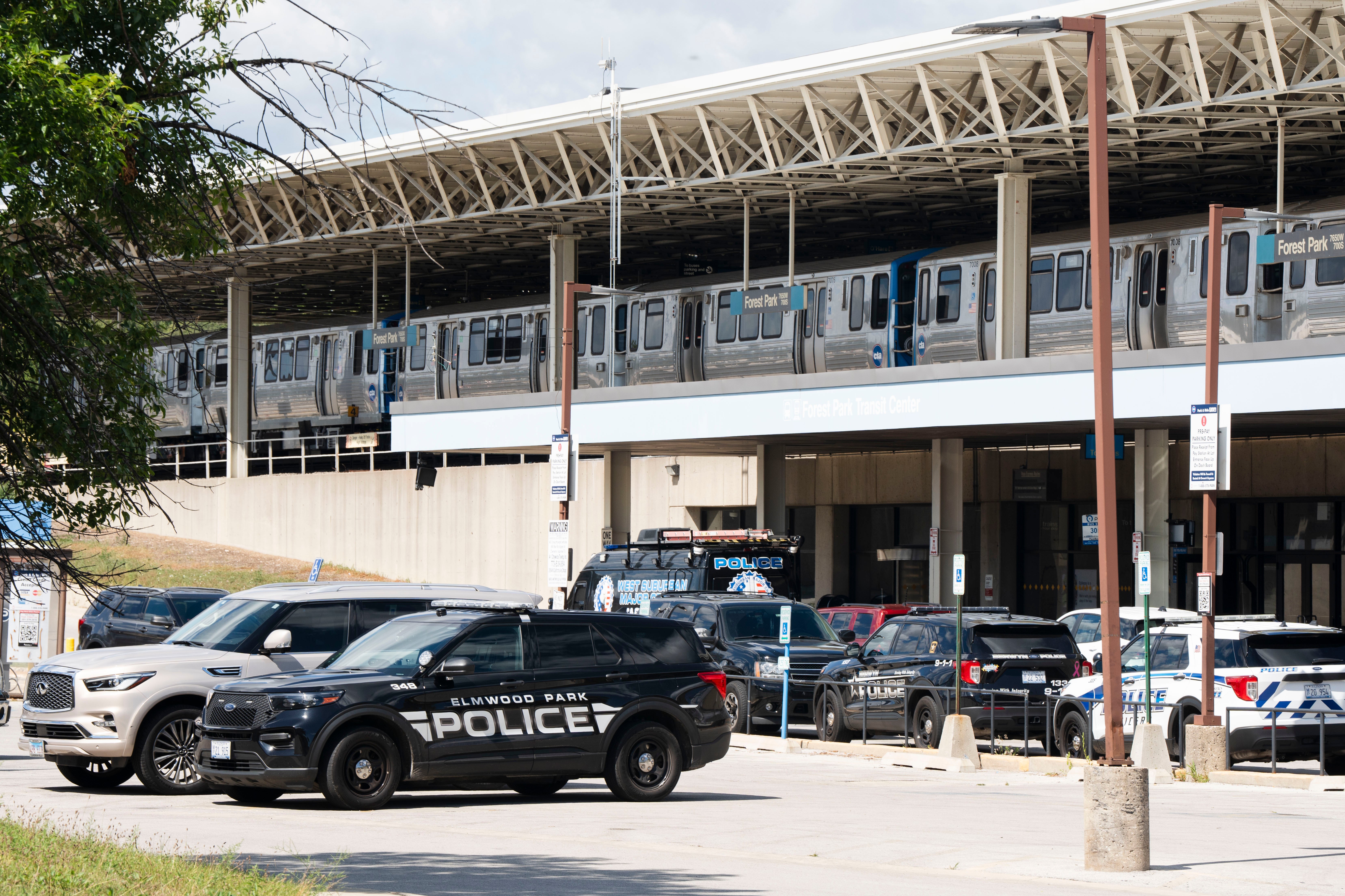 Police cars sit outside the Forest Park station. Officers have arrested the suspected gunman who killed four people on a Chicago Transit Authority Blue Line train early Monday