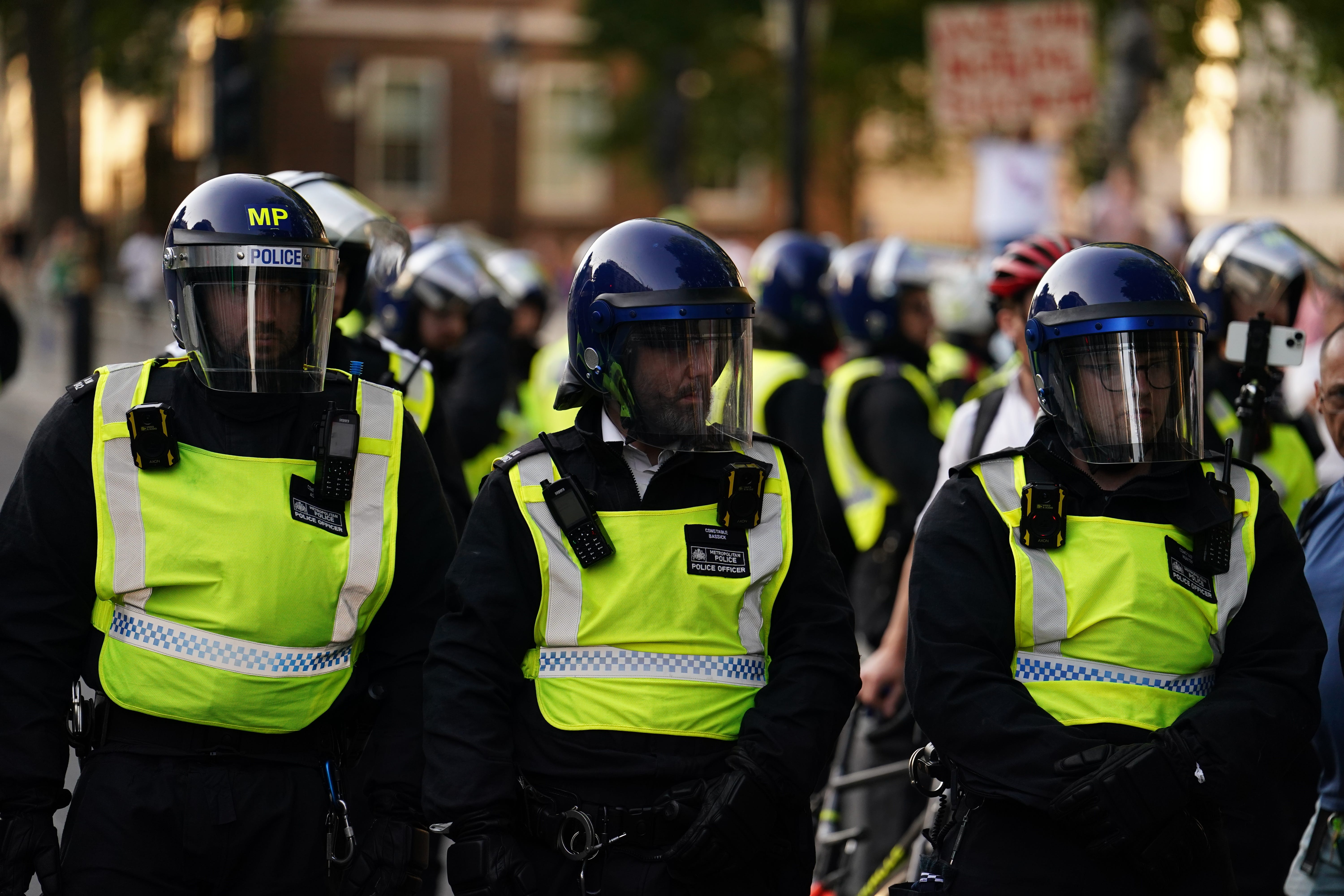 Police officers look on as people attend a protest in Whitehall, London, following the fatal stabbing of three children at a Taylor Swift-themed holiday club in Southport (Jordan Pettitt/PA)