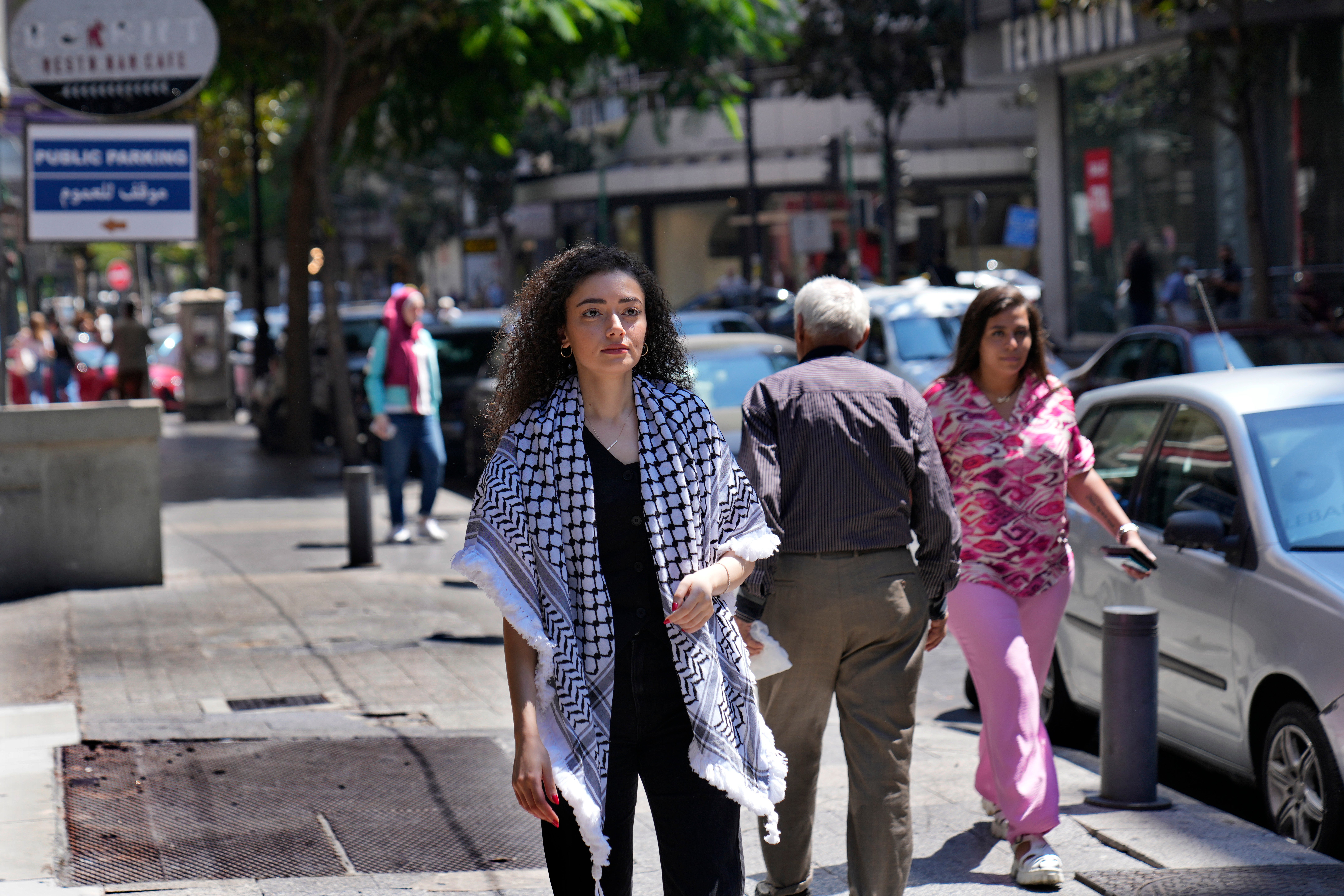 Plestia Alaqad, a young Palestinian journalist, walks in Hamra street in Beirut, Lebanon, Tuesday, Sept. 3, 2024. (AP Photo/Hussein Malla)